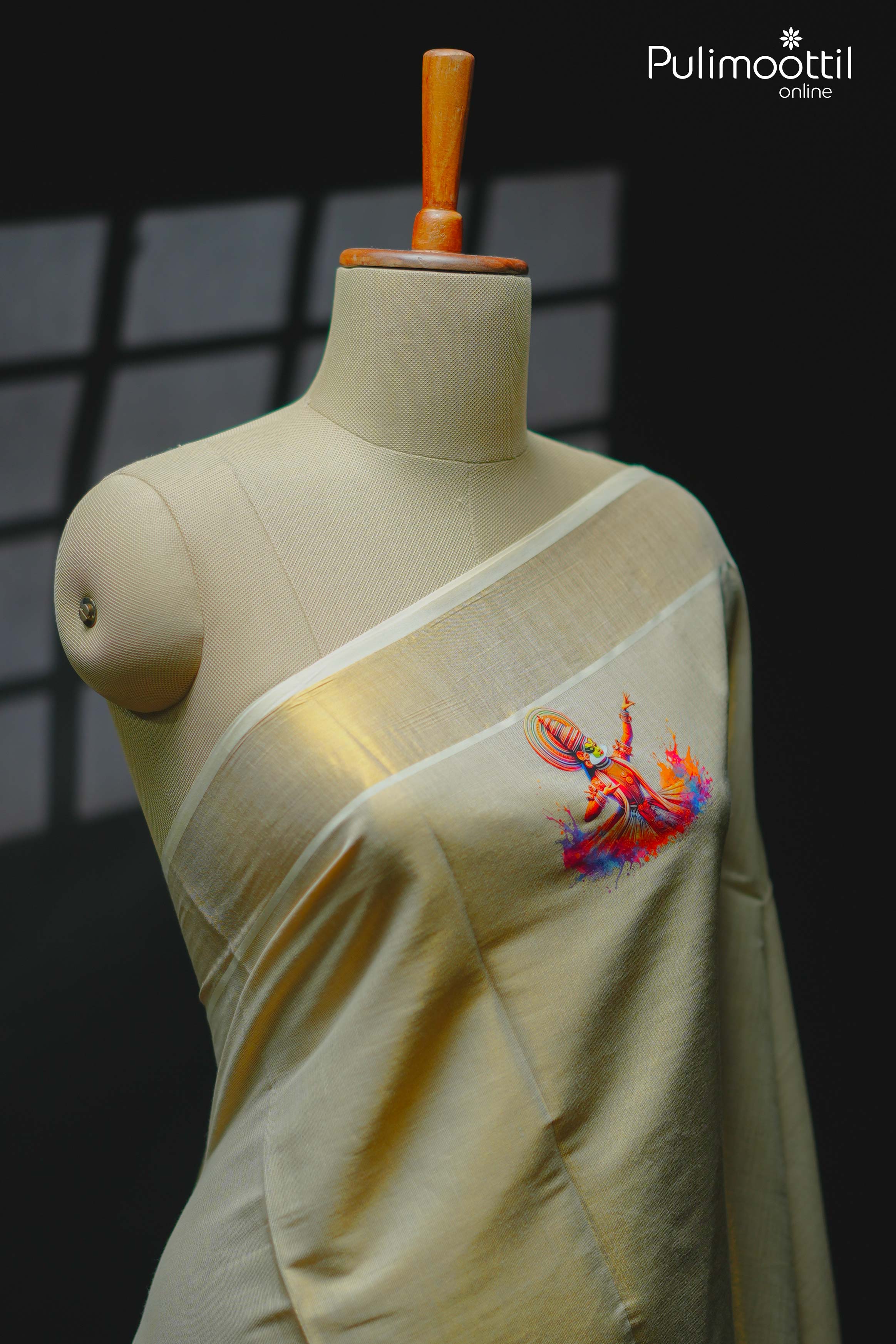 Cream‑gold Kerala tissue saree draped on mannequin with single vibrant Kathakali dancer print on the plain body and golden kasavu tissue border along shoulder edge.