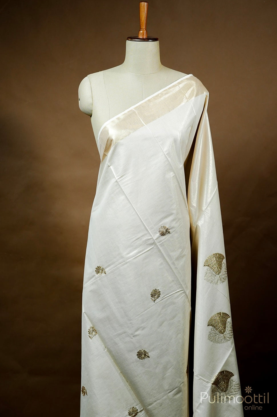 Off white Kerala traditional set saree with golden tissue border and machine embroidery design draped on mannequin
