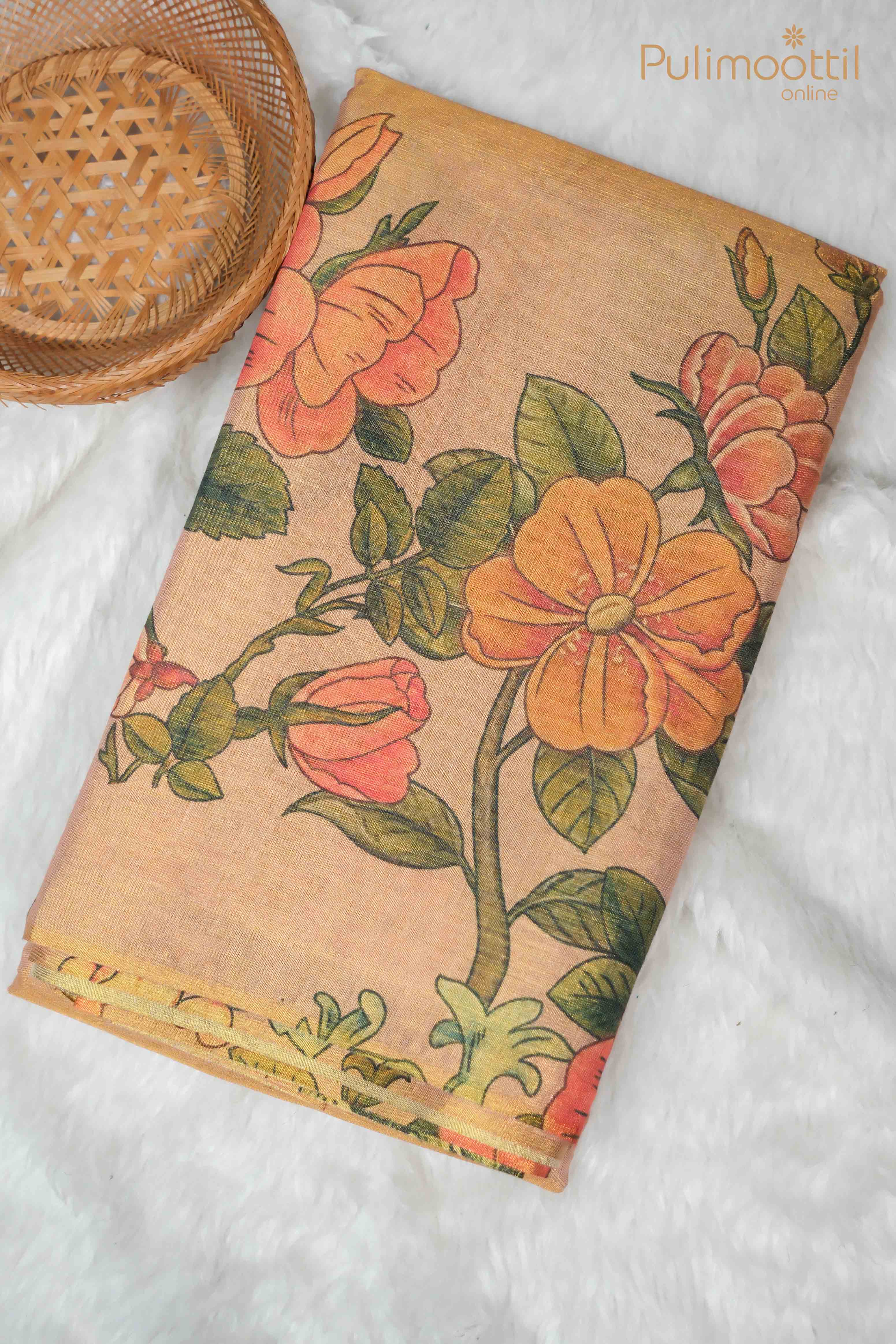 Folded Golden Tissue Onam Kerala Traditional Set Saree with a vibrant floral digital print, featuring orange and pink flowers on one side, and no border. A woven basket is placed beside the saree on a soft, white surface.