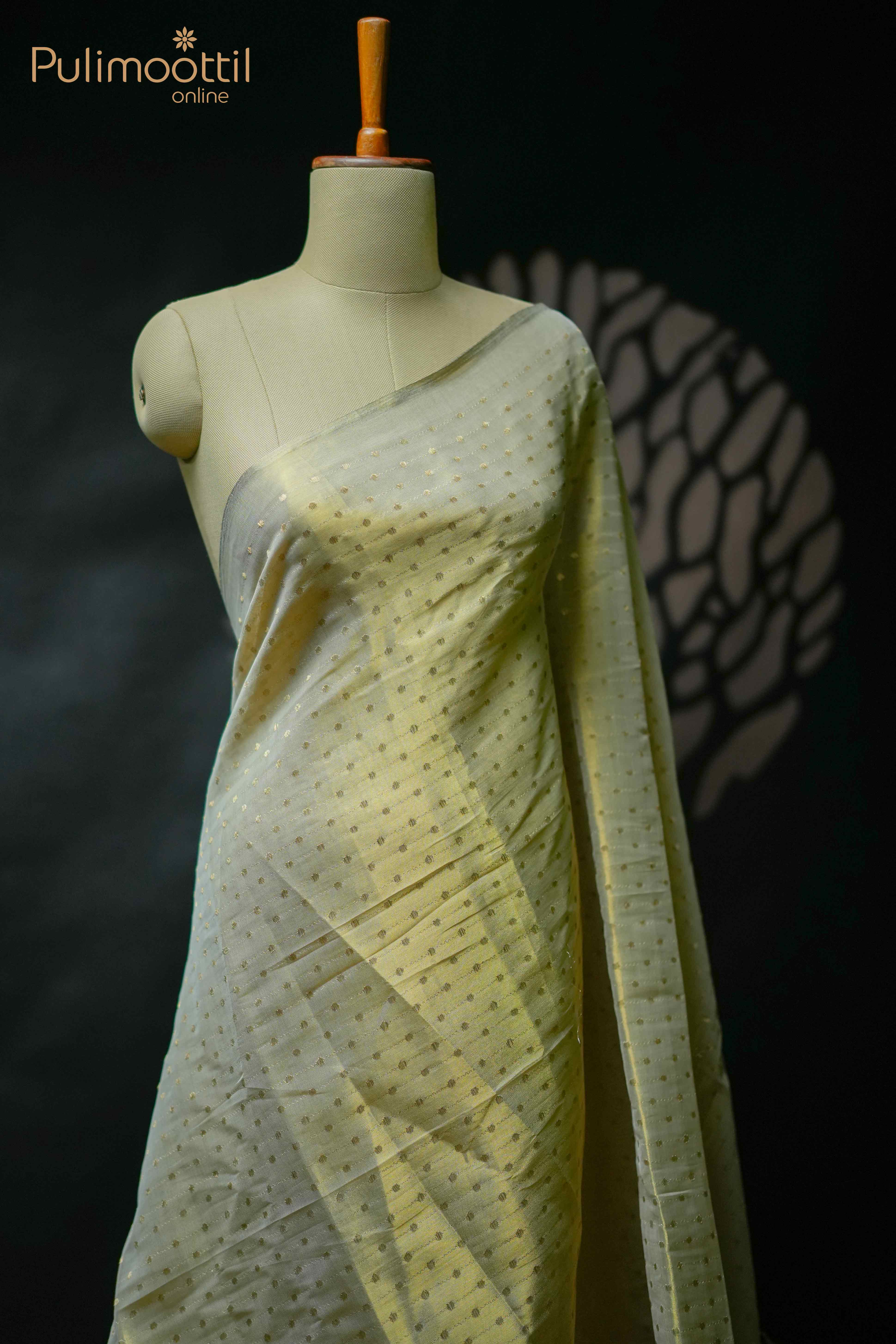 Golden tissue organza saree with zari buttas and borderless design, draped on mannequin — lightweight festive saree for women.