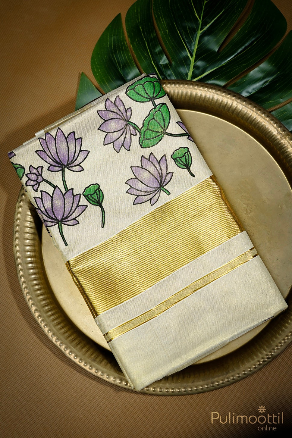 Golden tissue Kerala set saree folded neatly with purple floral print and golden border, displayed on decorative plate