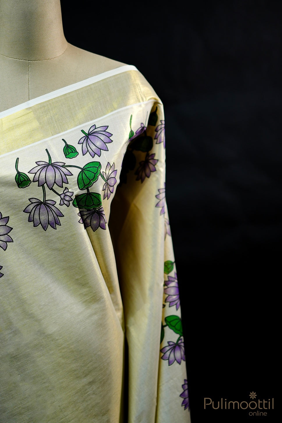 Close-up of golden tissue Kerala set saree on mannequin, showing purple floral print near golden border
