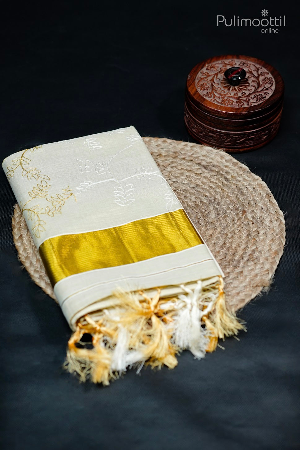 Golden tissue Kerala set saree with plain body, delicate thread work and golden border, folded with tassels on display