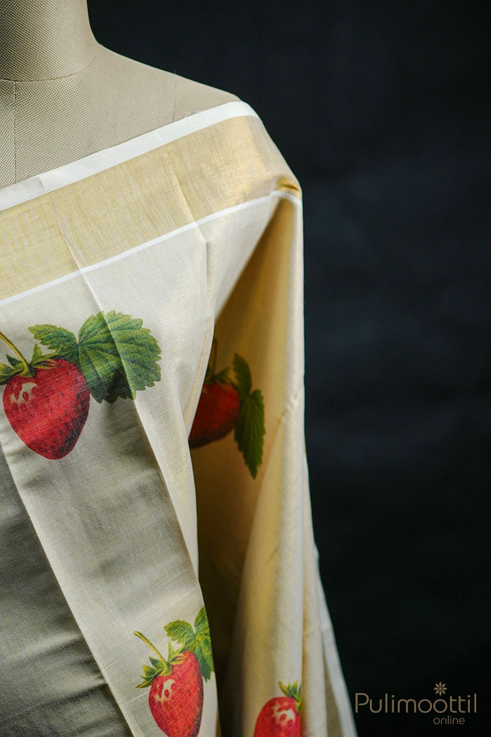 Close-up of blouse piece showing a single red strawberry print with green leaf on plain tissue fabric.
