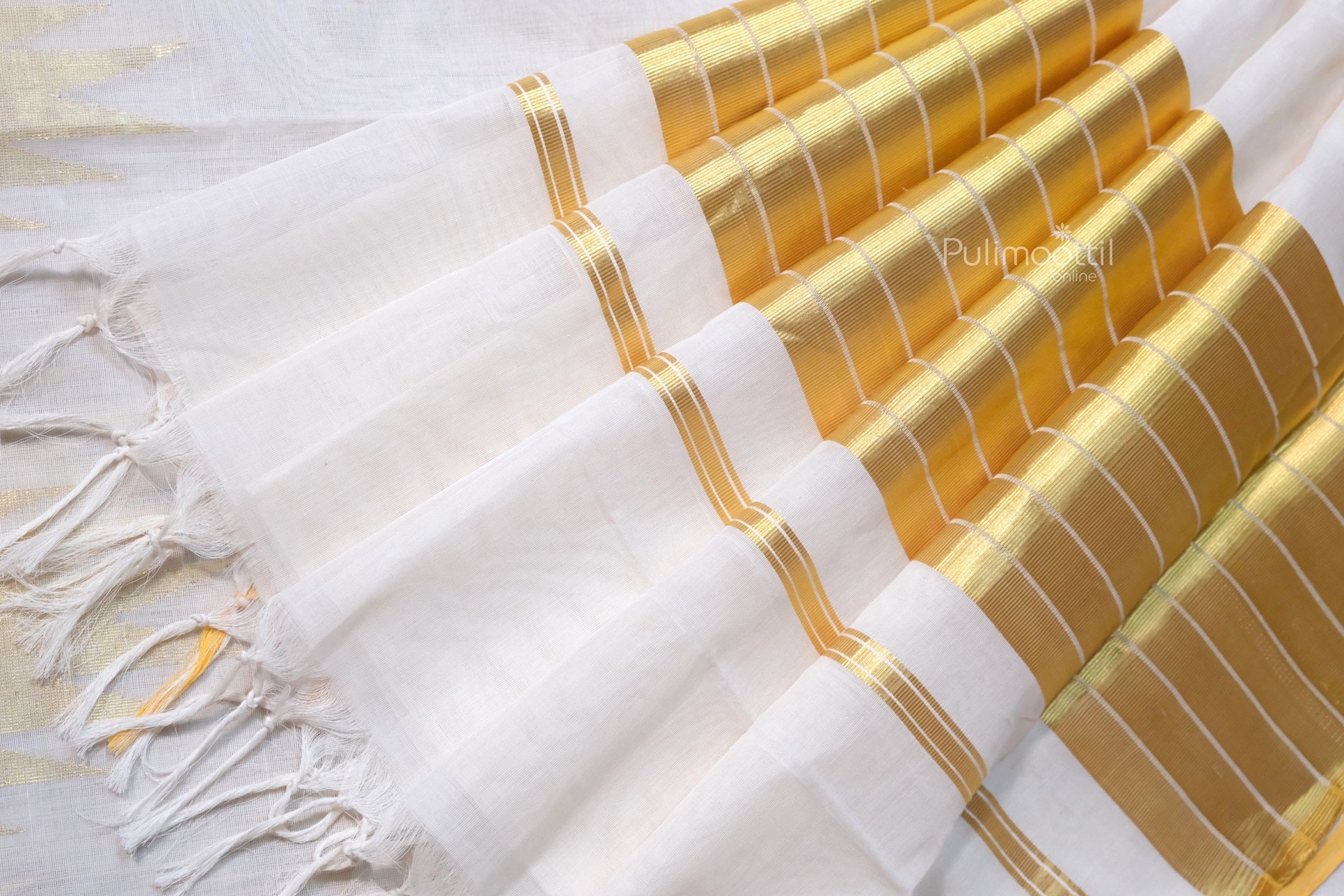 Pallu section of Kerala saree featuring lustrous golden zari with orange border detail