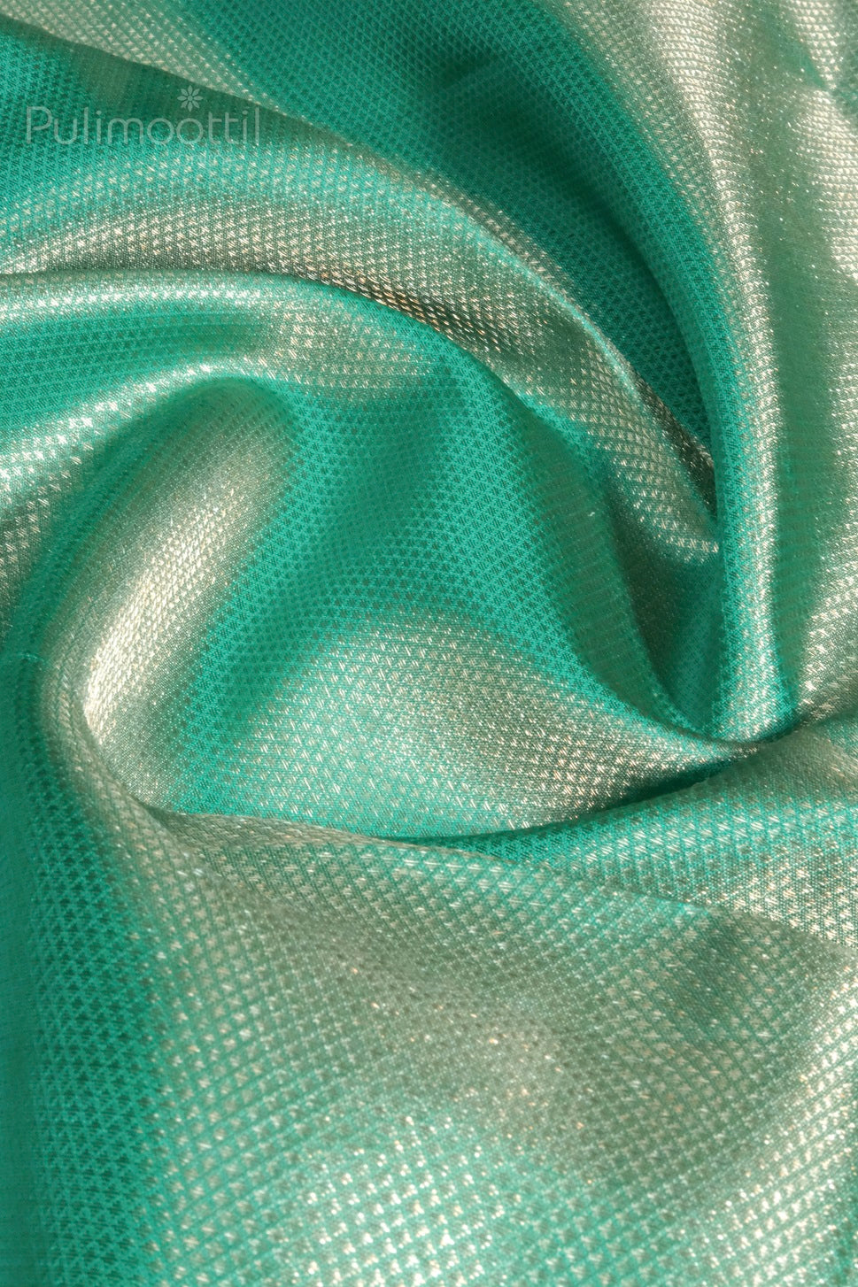 close-up of jungle green brocade blouse fabric with metallic gold floral pattern