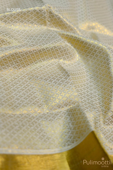 Close-up view of blouse piece featuring intricate golden zari weave on cream-white base for Kerala brocade saree.