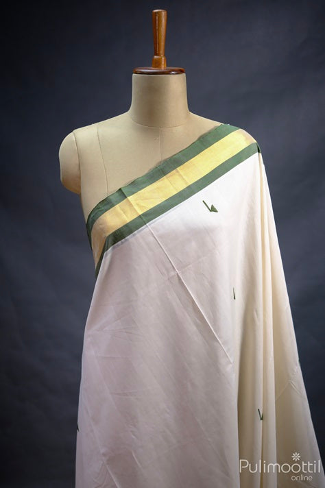 Kerala traditional handloom set saree in off-white with green thread butta and golden tissue border, draped on mannequin – ideal for Onam and festive wear.