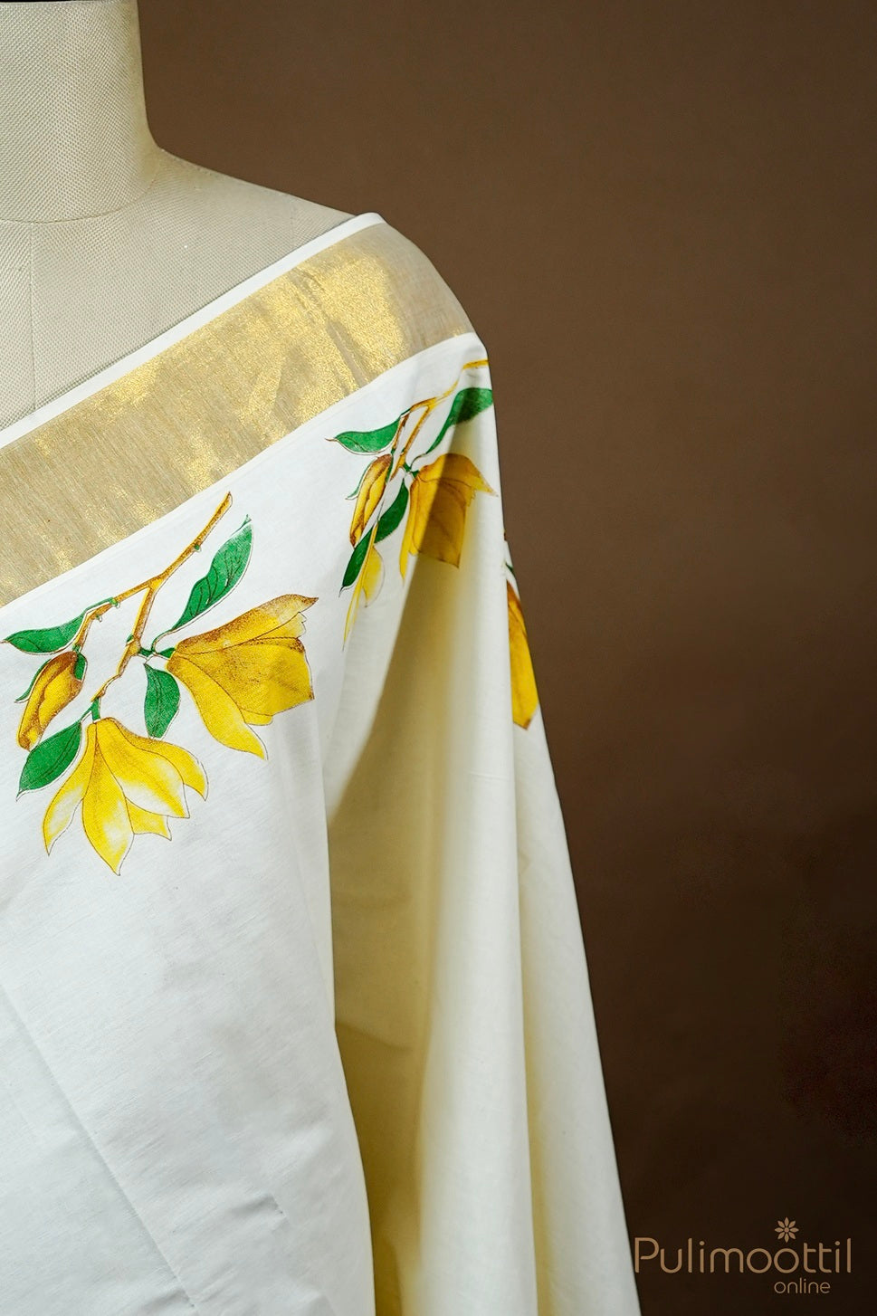 Half-side view of mannequin draped in Kerala saree with yellow floral print and golden tissue border