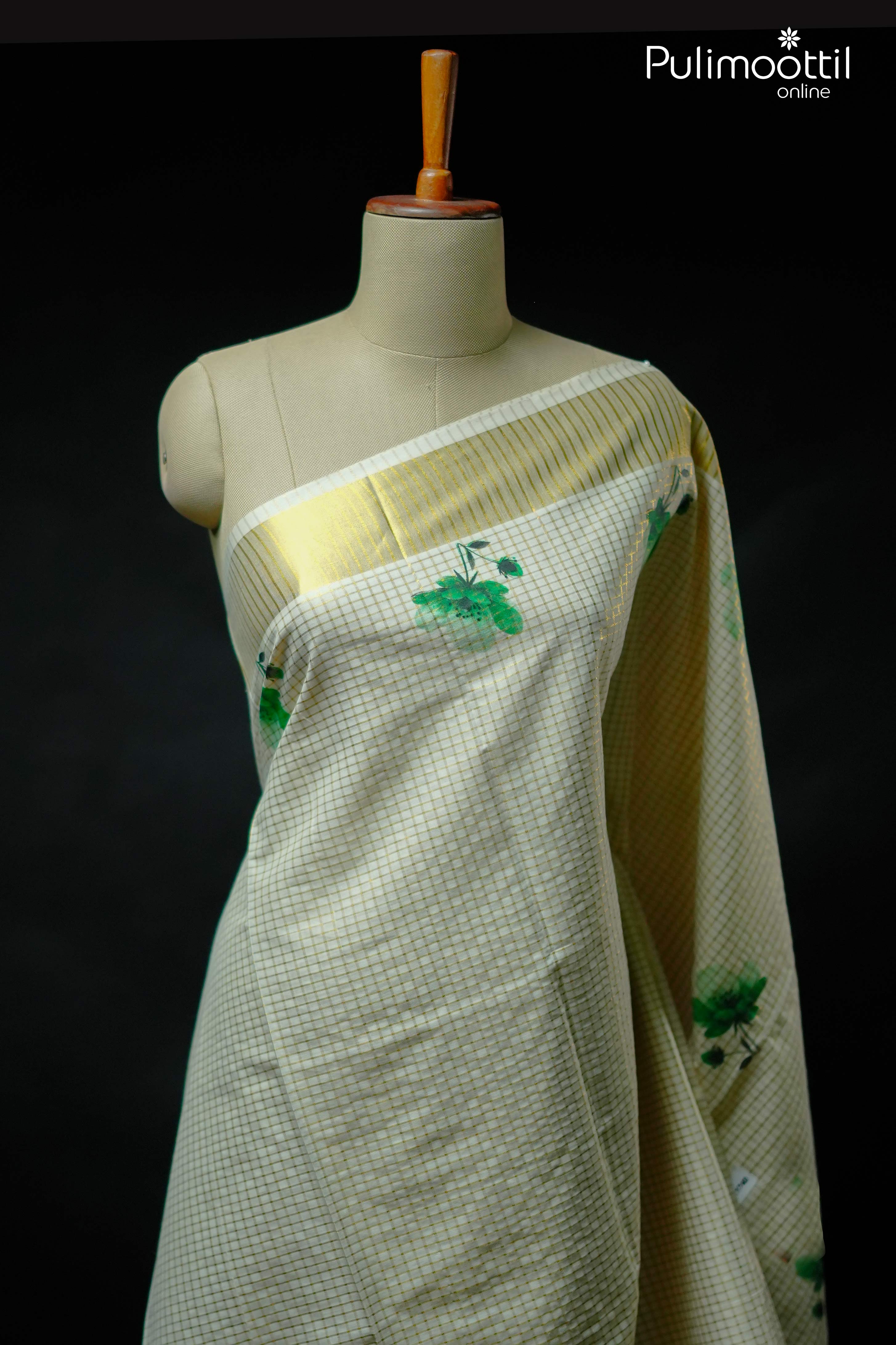 Kerala traditional set saree with golden zari check and green floral design on body, finished with golden tissue border, displayed on mannequin.

