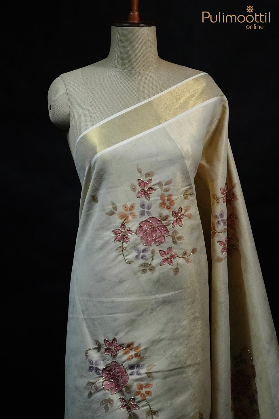 Kerala traditional tissue set saree with golden border and floral printed body embellished with beads and sequence work – Onam Kerala saree displayed on mannequin.