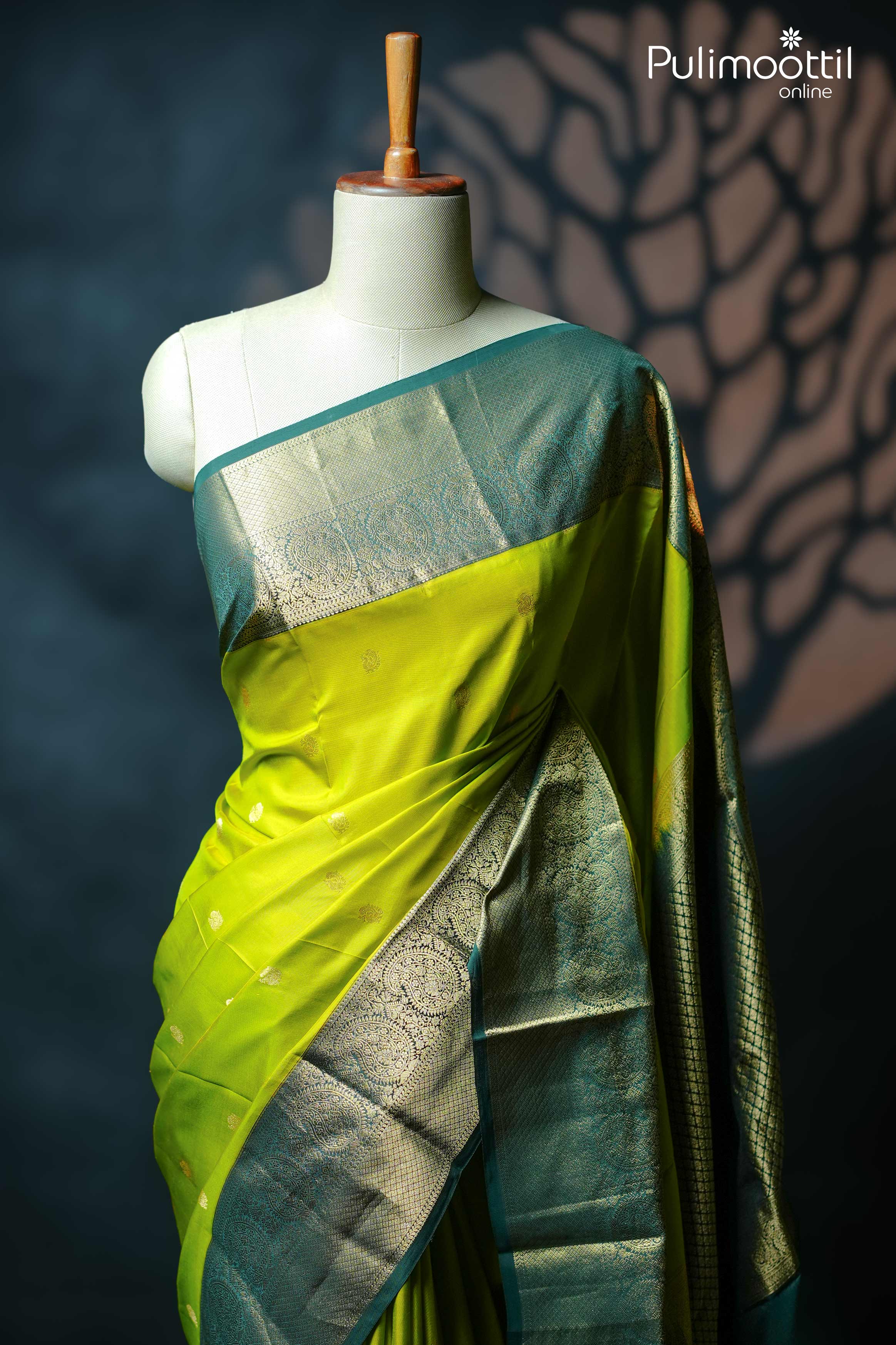 Lime green Kanchipuram silk saree with golden zari peacock motifs and contrast green traditional border and pallu displayed on mannequin