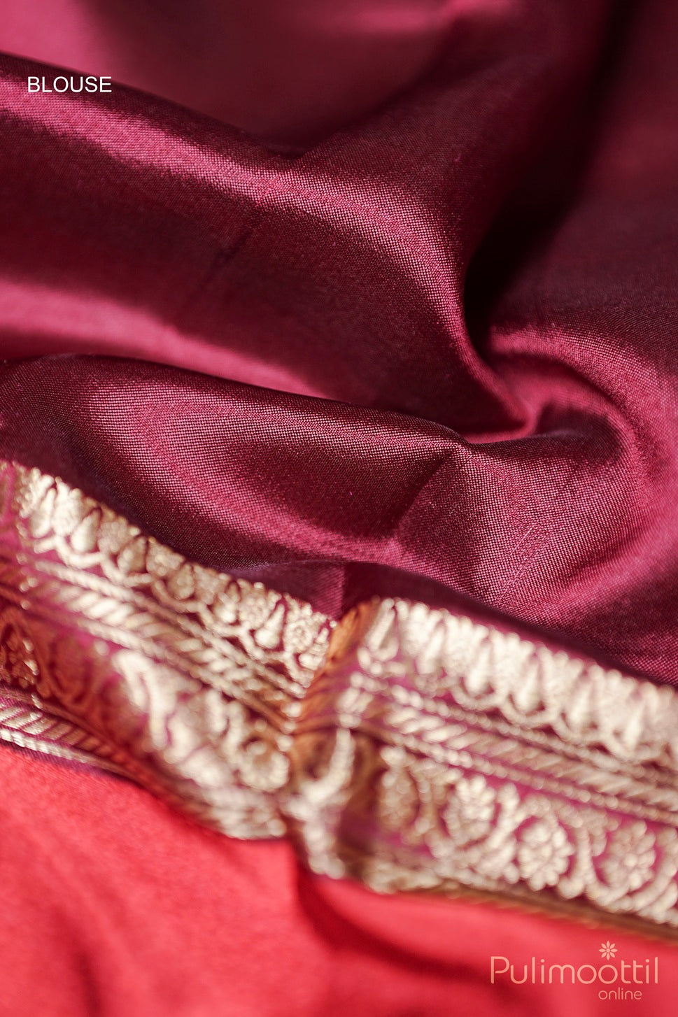 Close-up of maroon mango silk saree blouse piece with golden zari border detailing.