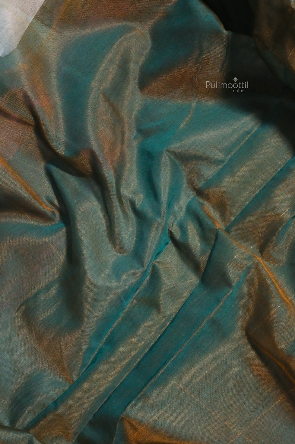 A flowing section of the saree emphasizing the lightweight texture and transparent finish, blending peacock blue and brown shades with a hint of golden sheen.