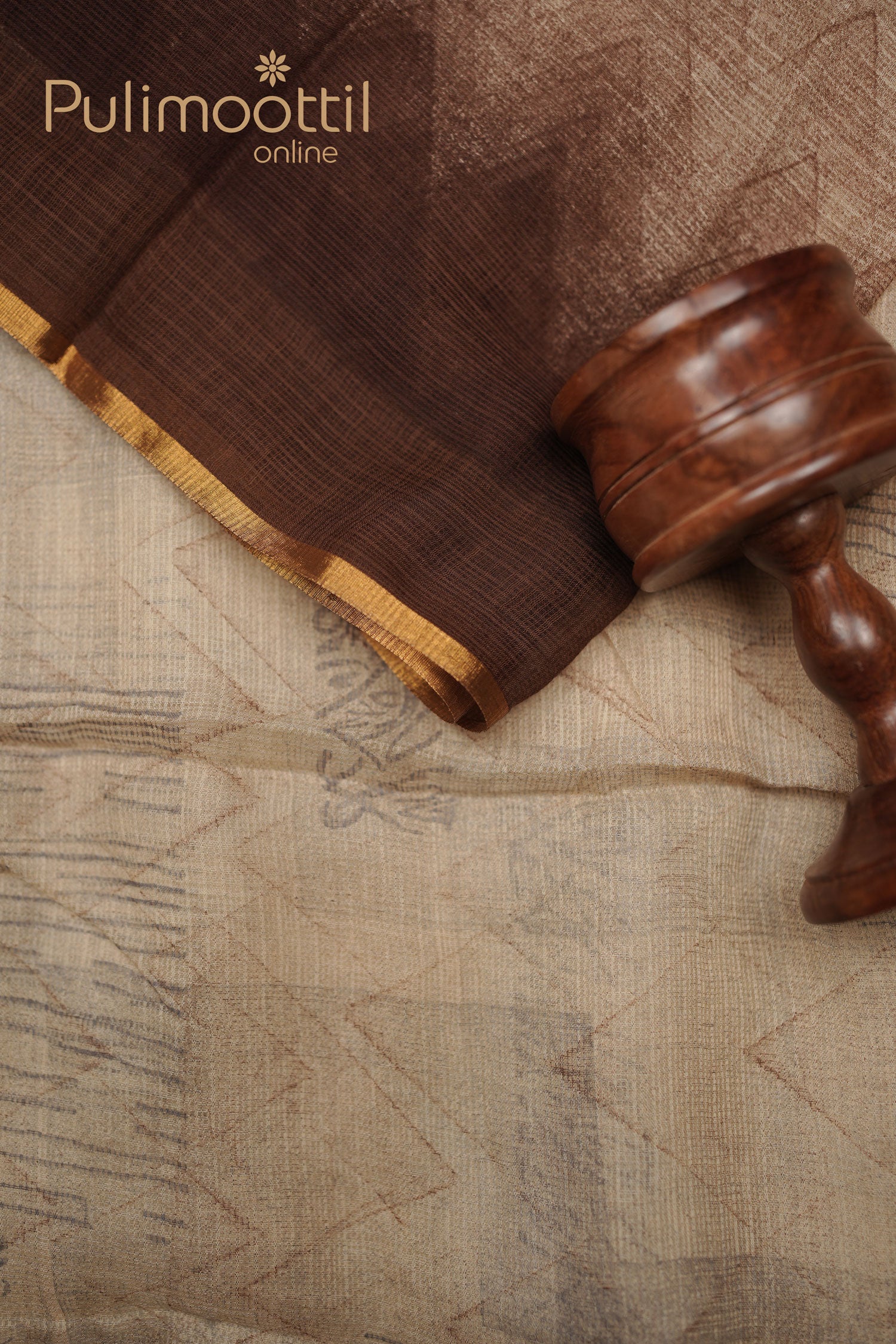 Multi-shaded soft net-cotton saree with geometric zigzag and line patterns, featuring a golden thin border, placed with a wooden prop.