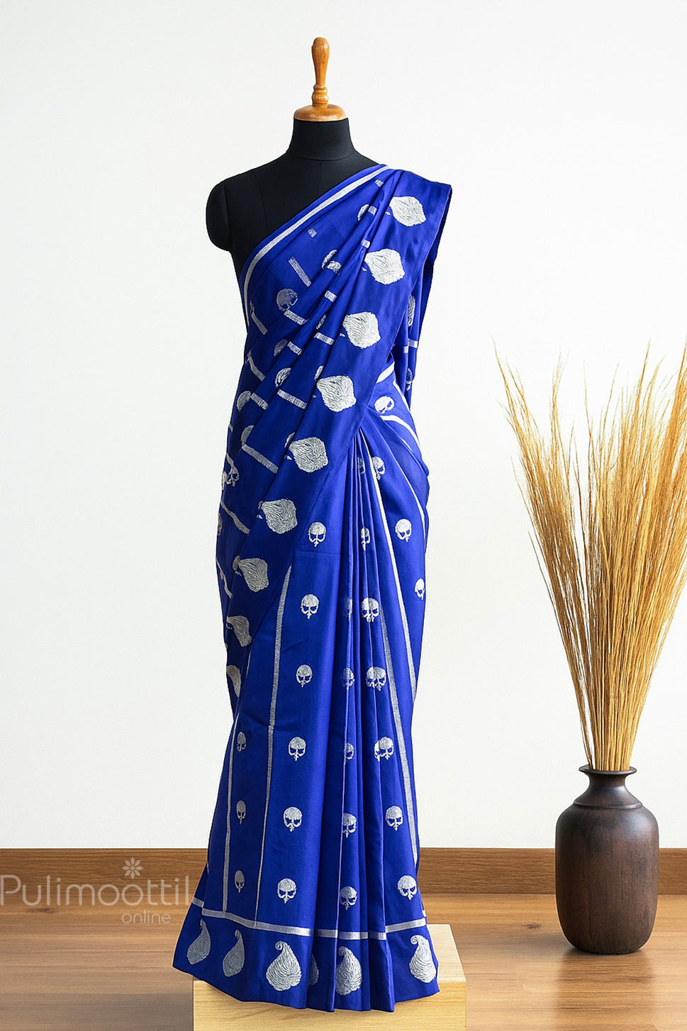 Navy blue Banarasi silk saree draped on mannequin with silver and gold zari floral motifs, vertical stripe texture, and one-side mango design border.