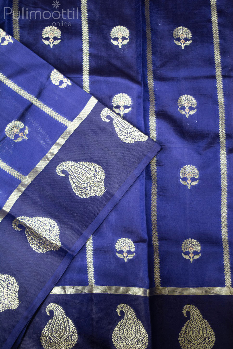 Navy blue Banarasi silk saree laid flat showing gold and silver zari floral motifs with vertical stripes and rich mango design border on the pallu.

