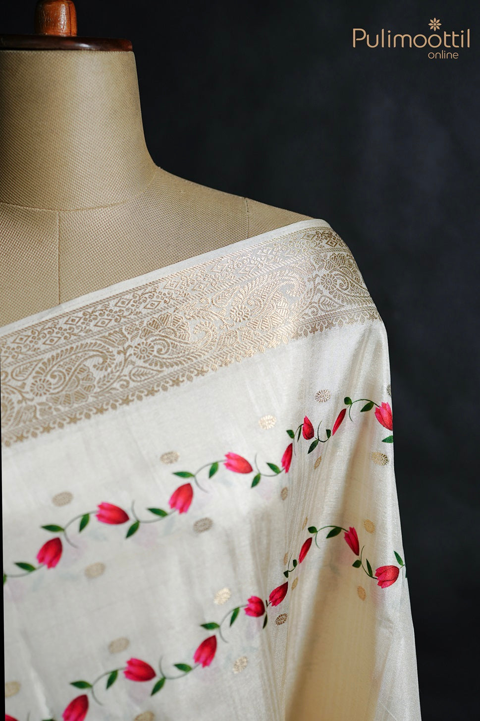 Close-up of mannequin wearing off white semi tissue silk saree, showcasing printed body and antique zari designer border from the top right angle.