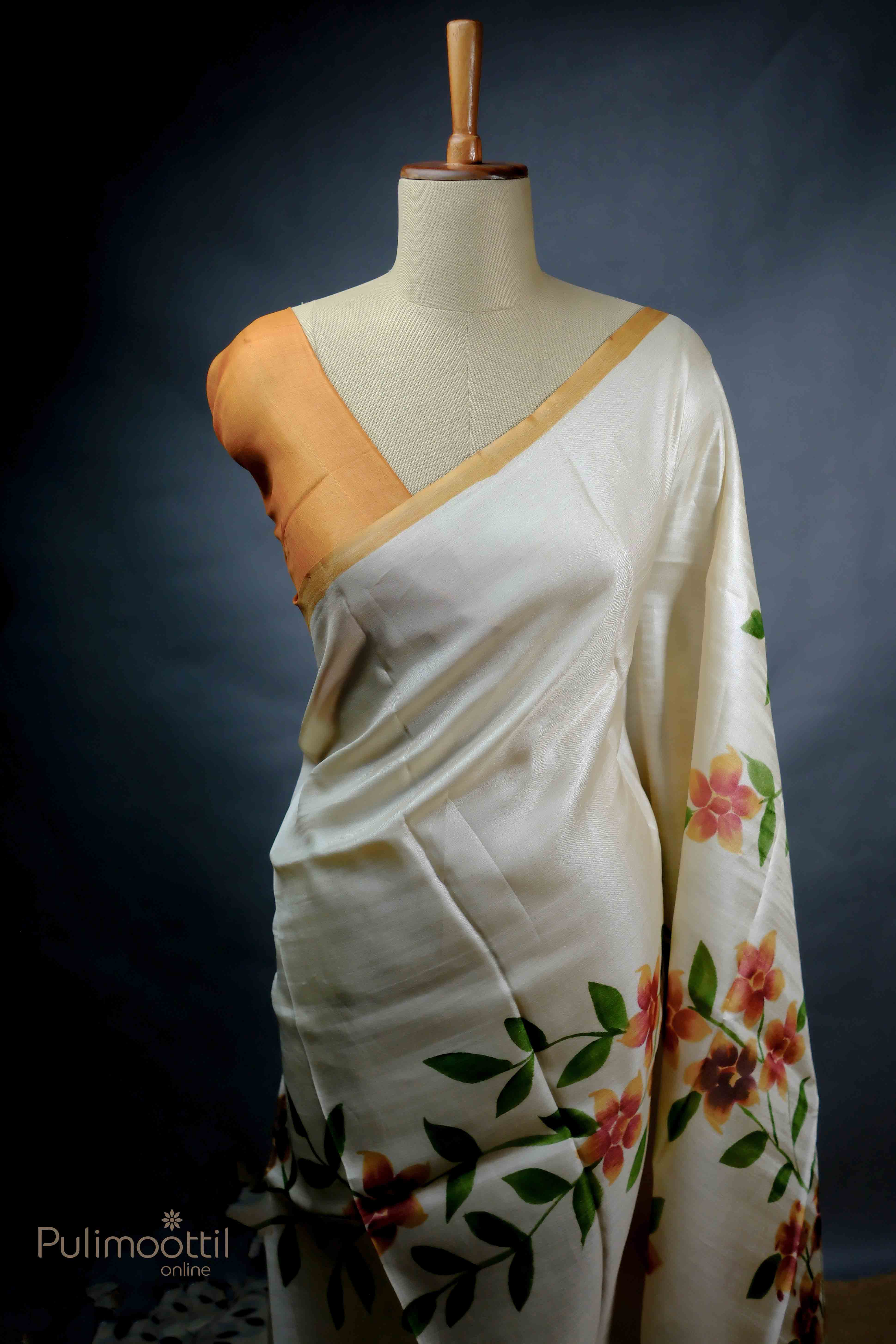 Off-white pure Tassar saree with floral prints and contrast orange border, styled on a mannequin.