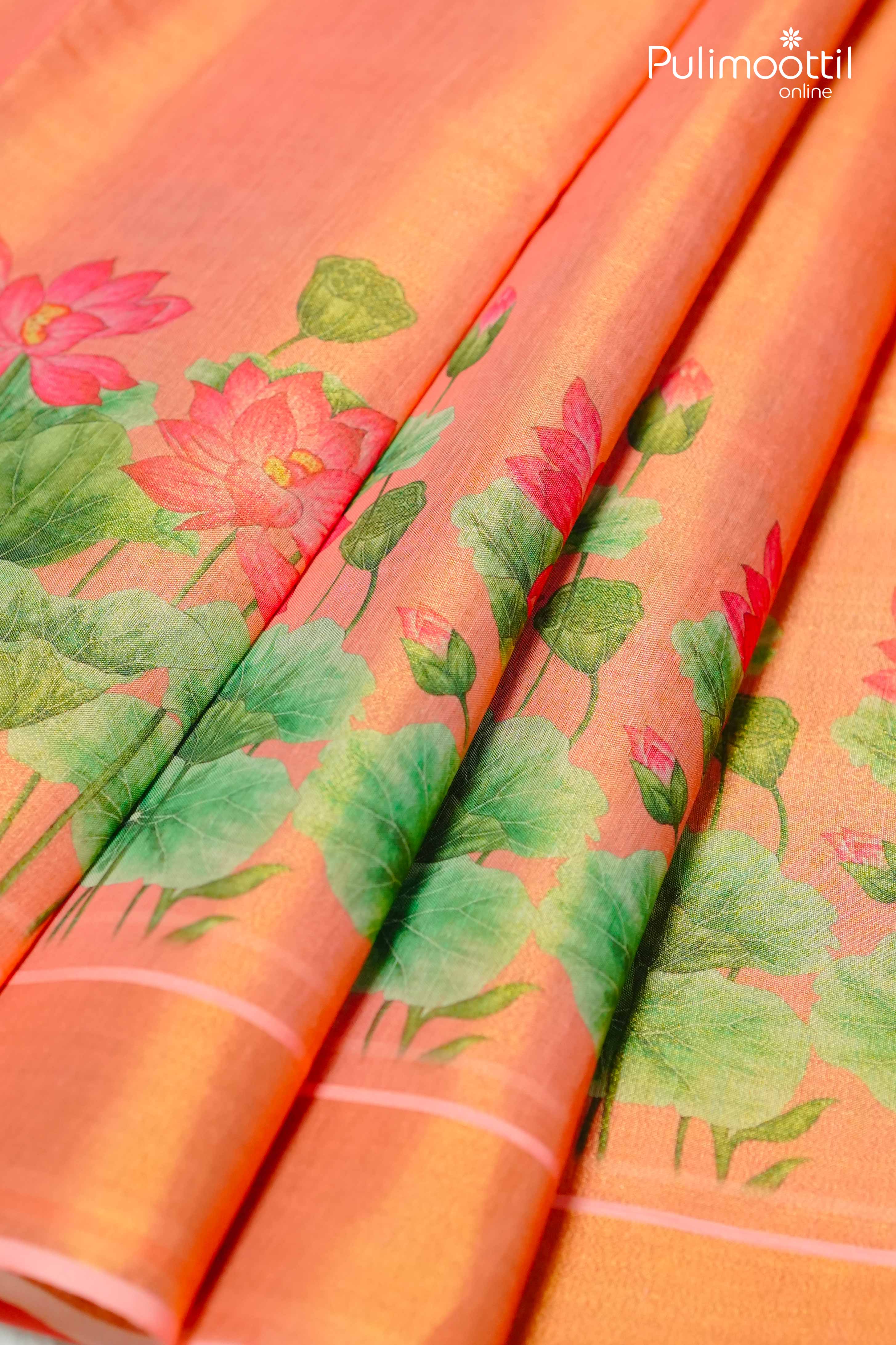 Orange Kerala tissue saree body with large lotus floral print and leafy green motifs, featuring a soft tissue border.
