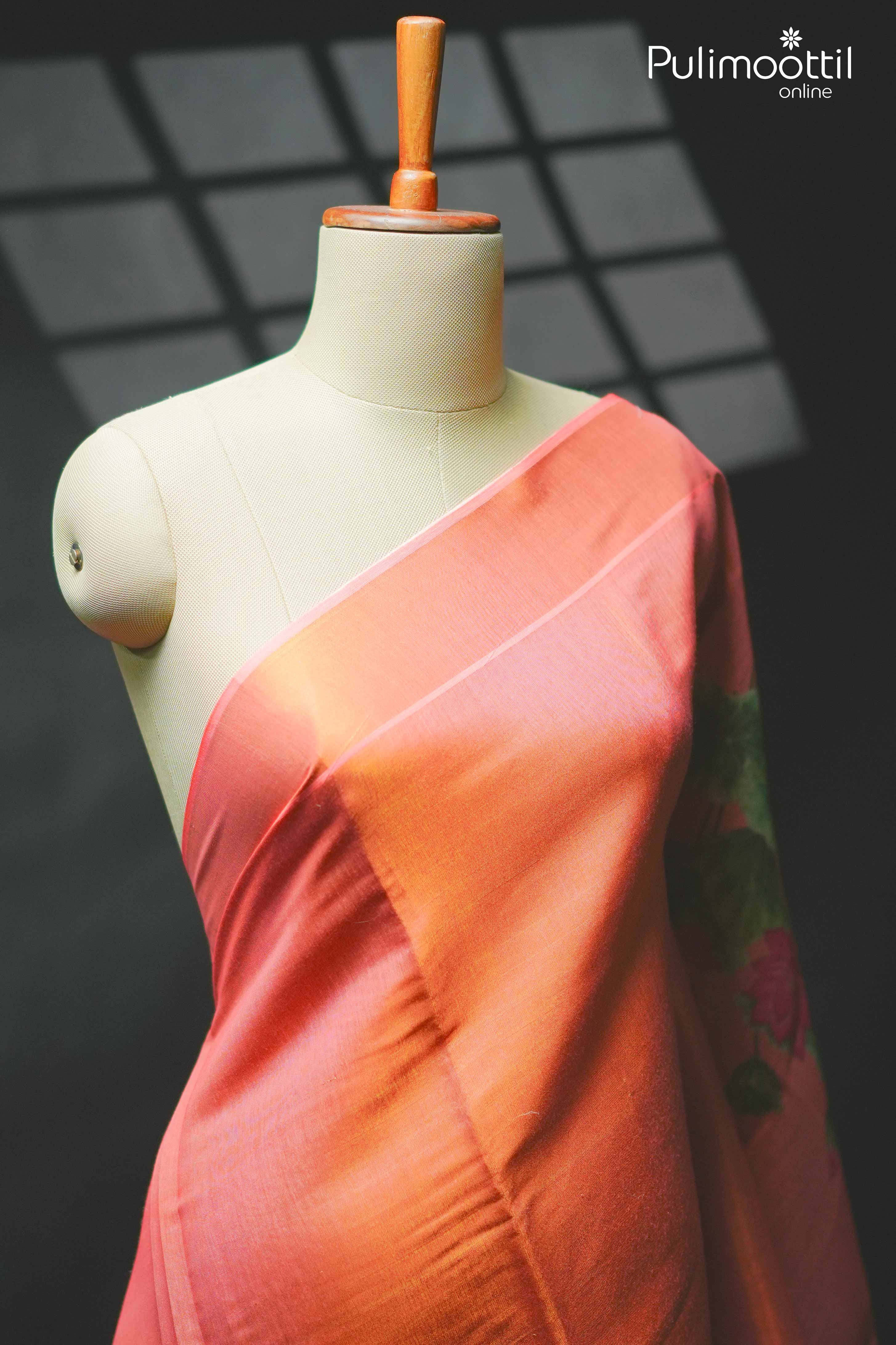 Orange Kerala tissue saree displayed on mannequin, showing plain body with subtle sheen and soft tissue border.