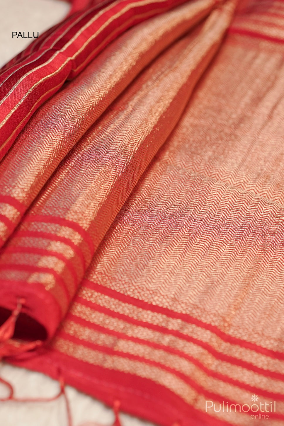 	Red and gold woven saree pallu with intricate patterns and striped border, traditional Indian design