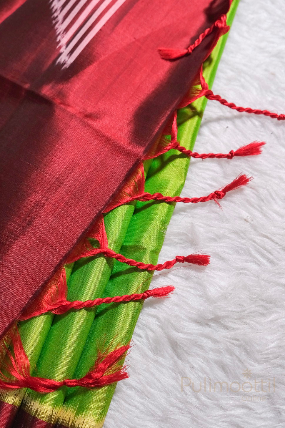 Rich maroon soft silk fabric draped with flowing folds and a subtle lustrous sheen.