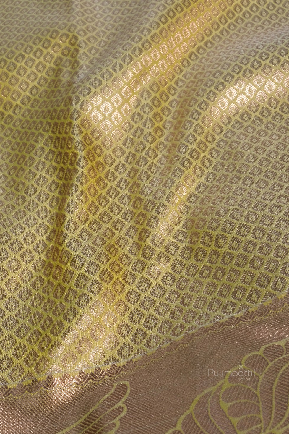 Pastel yellow Kanchipuram saree with golden pallu laid flat to display full design and traditional craftsmanship.