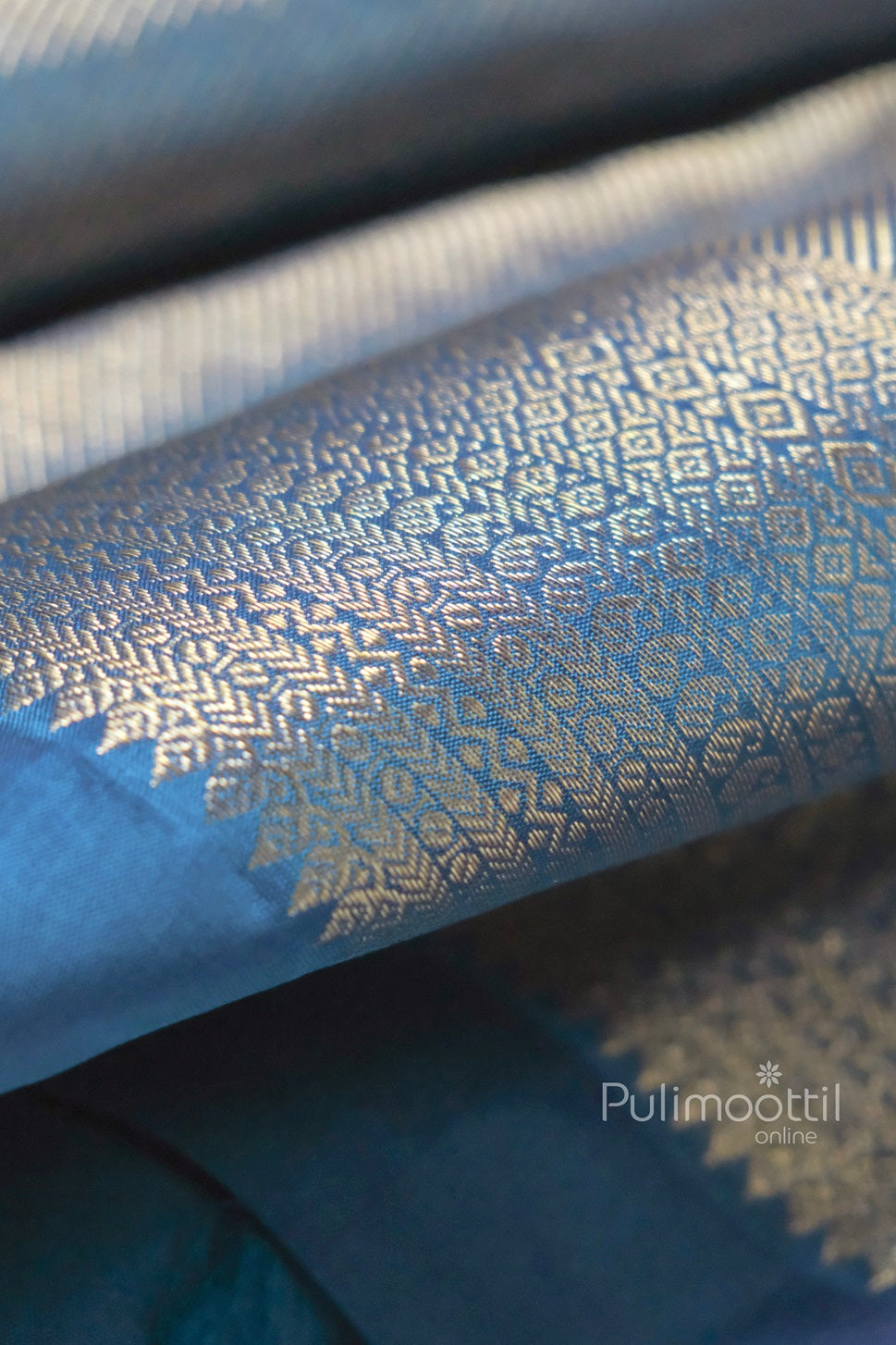 Close-up view of navy blue Banarasi silk saree with shimmering golden zari weave and intricate geometric border, ideal for bridal and festive occasions.
