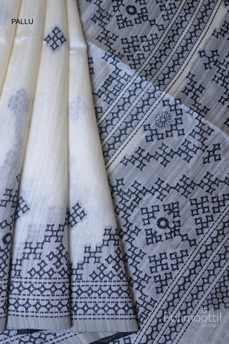 Off-white semi jute silk saree with black Kutch work buttas, focused on the intricate embroidery along the pallu and detailed border.