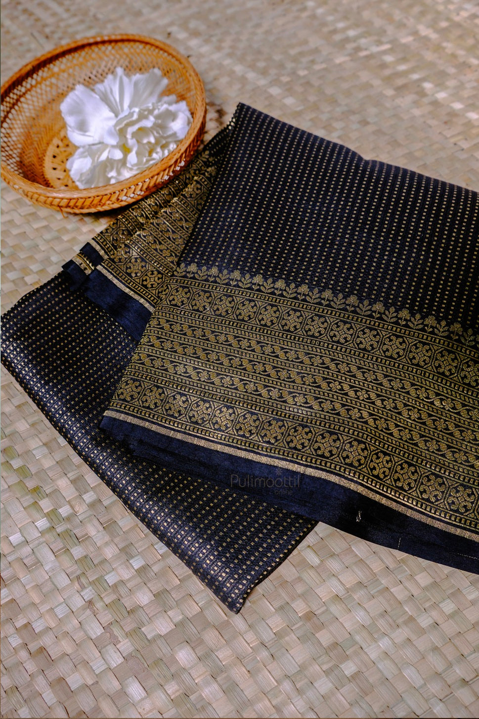 Elegant navy blue silk saree with intricate gold zari border and traditional Indian patterns displayed on woven fabric