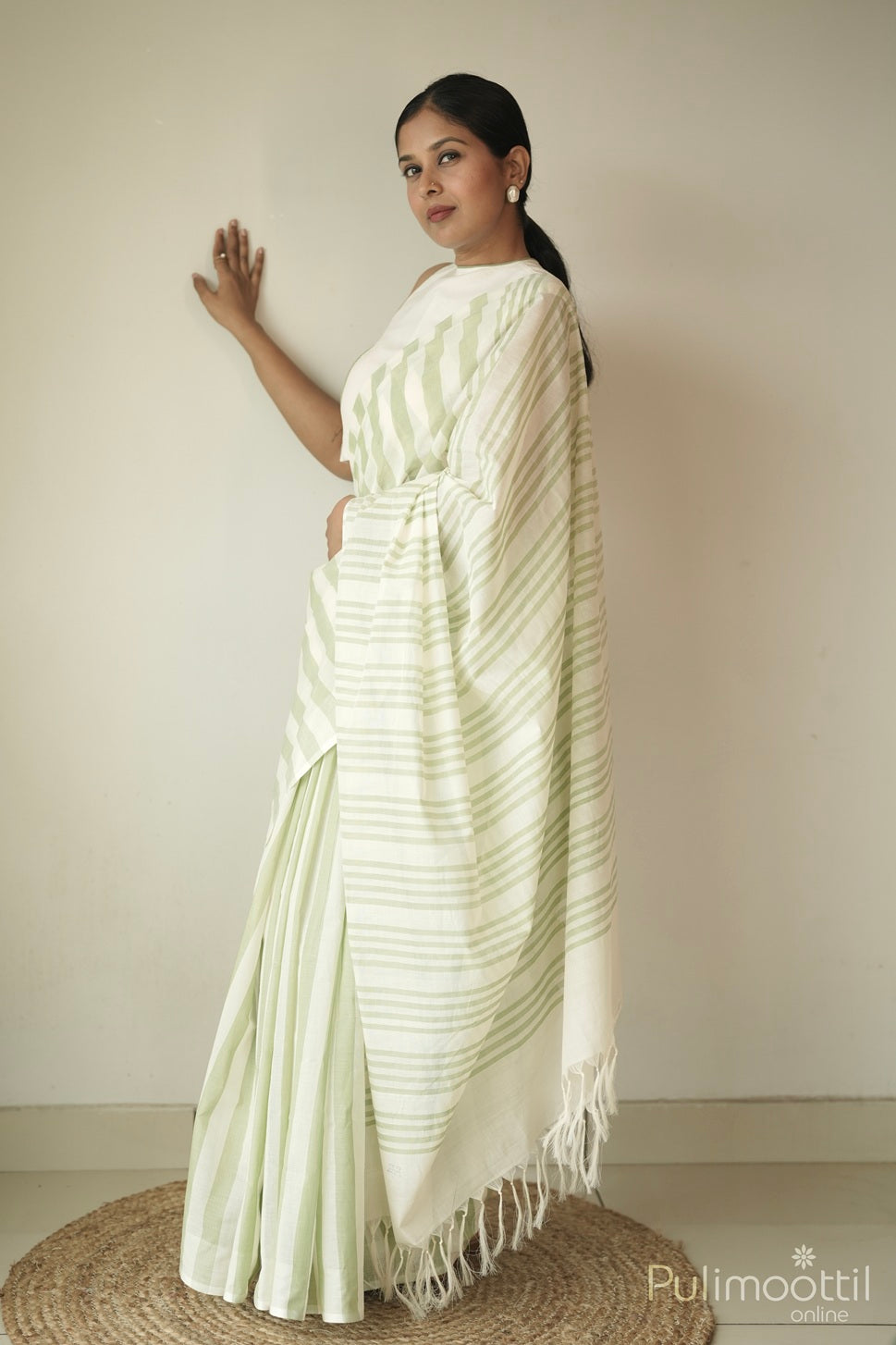 Pure handloom cotton saree in pastel green and cream stripes, borderless design draped on model – sarees under 5000.