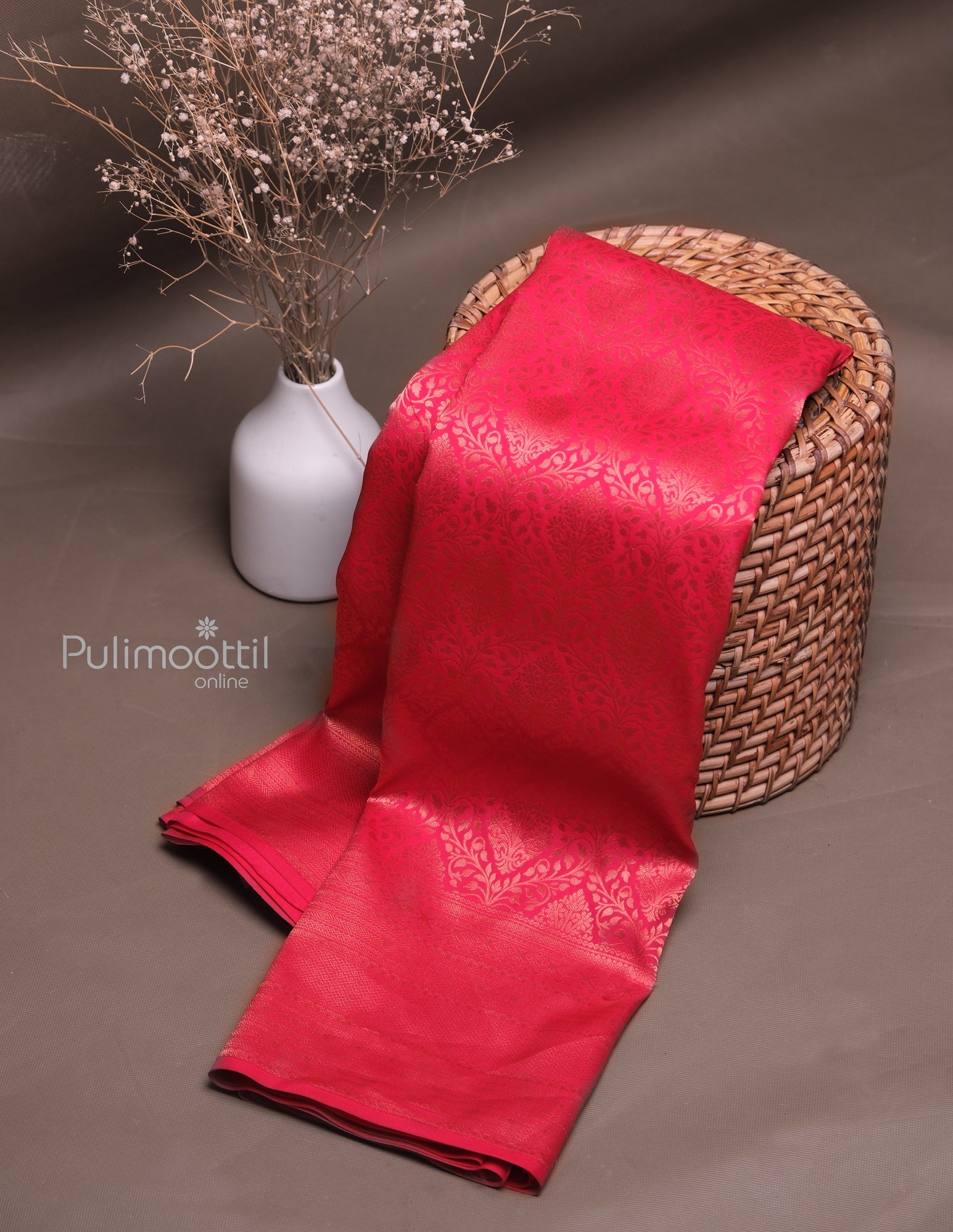 Elegant red silk saree featuring delicate woven patterns and traditional shimmer