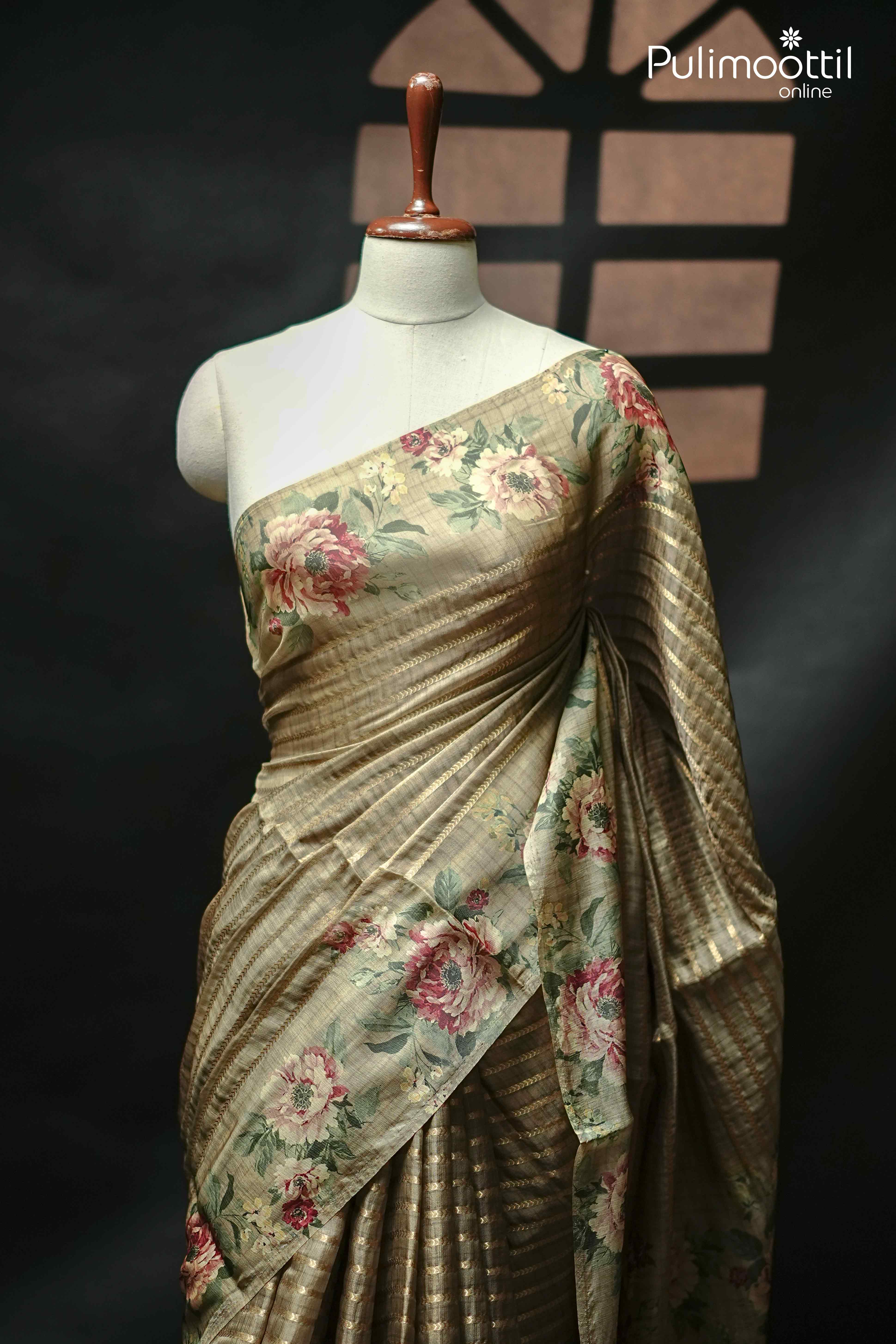 Behr green organza saree with golden zari lines and floral border, draped on mannequin to showcase soft sheer texture and elegant fall.