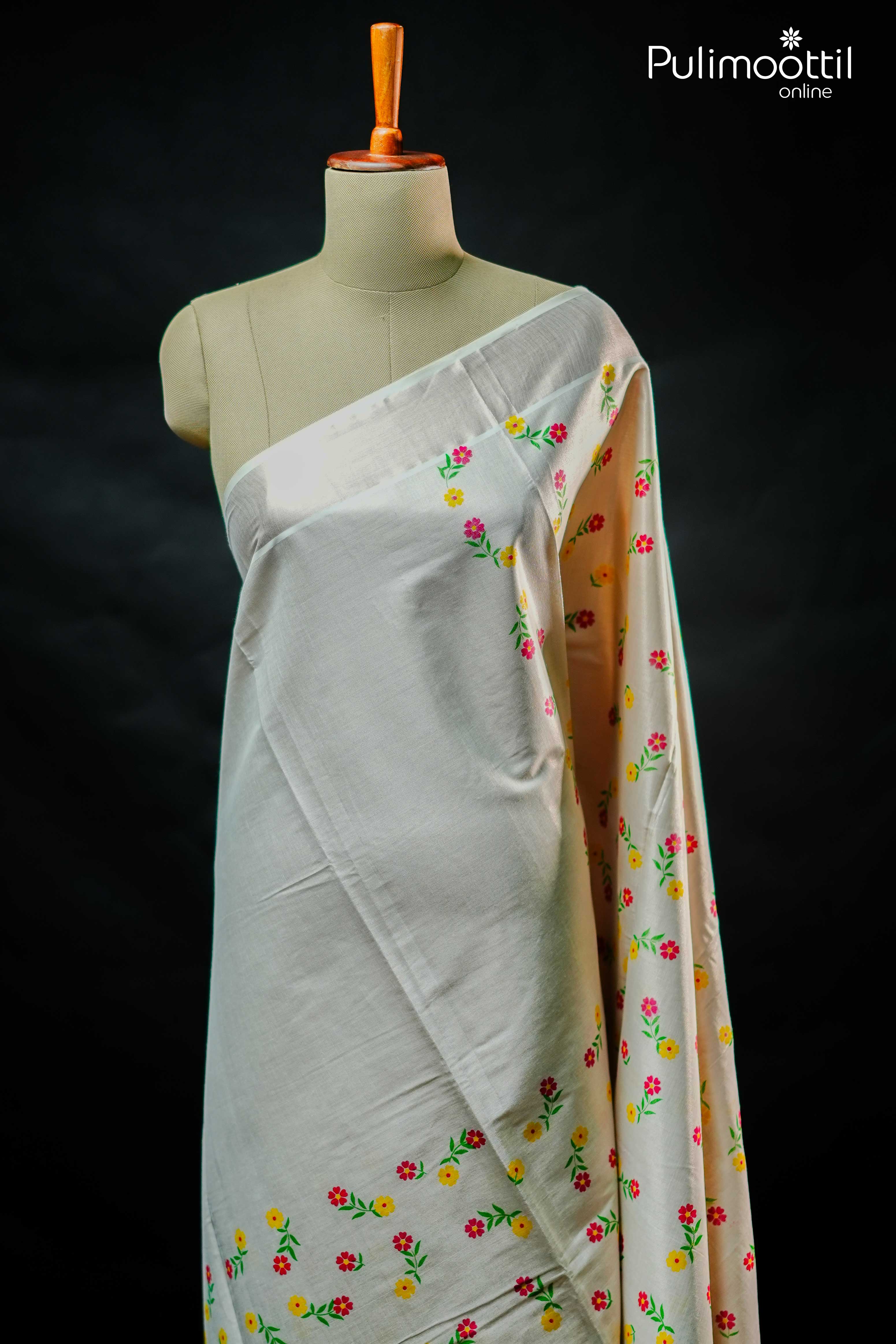Traditional Kerala tissue saree draped on mannequin with floral print and silver tissue border