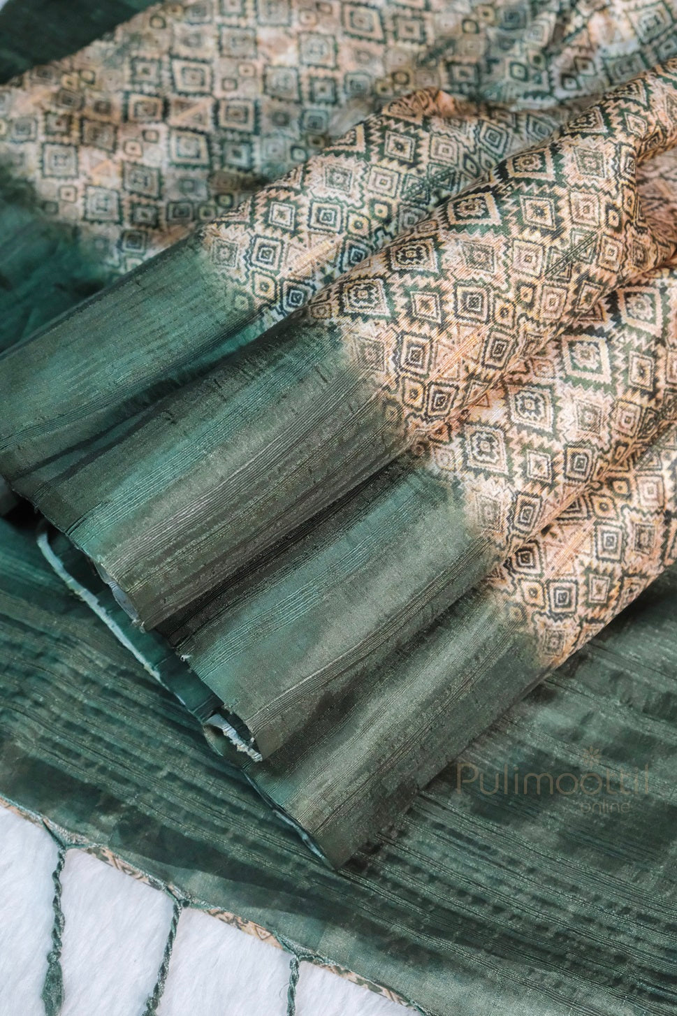 Elegant green soft silk saree with intricate golden zari diamond motifs and contrast pallu, displayed in pleated form with visible tassels and Pulimoottil Online branding.

