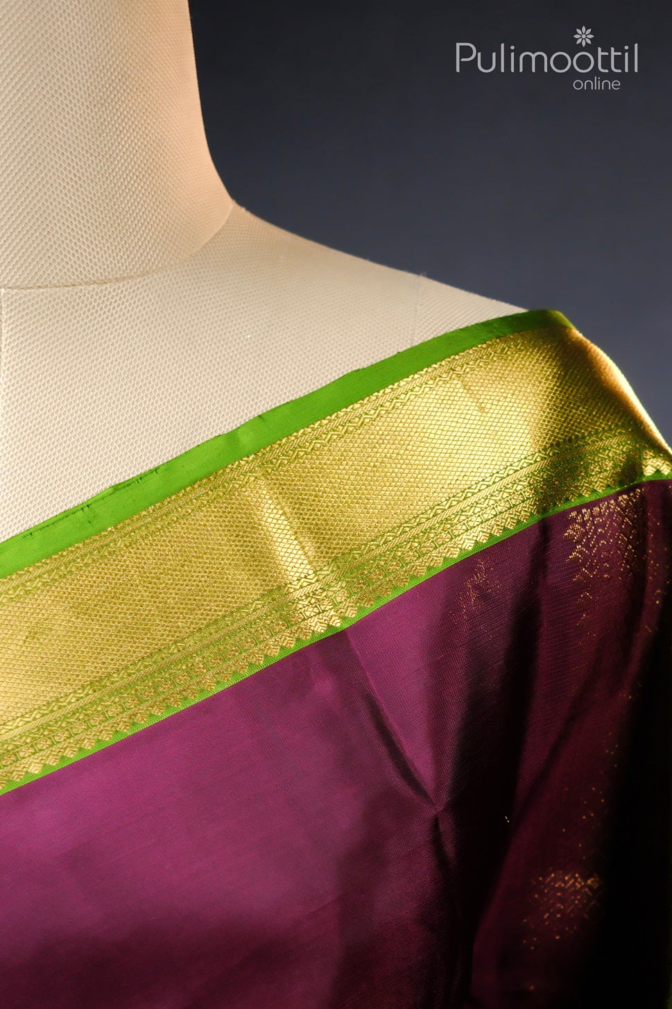 Close-up view of the shoulder section of the Wine Colour Pure Kanchipuram Silk Saree, showcasing the intricate golden zari border with a contrasting green edge, displayed on a mannequin.