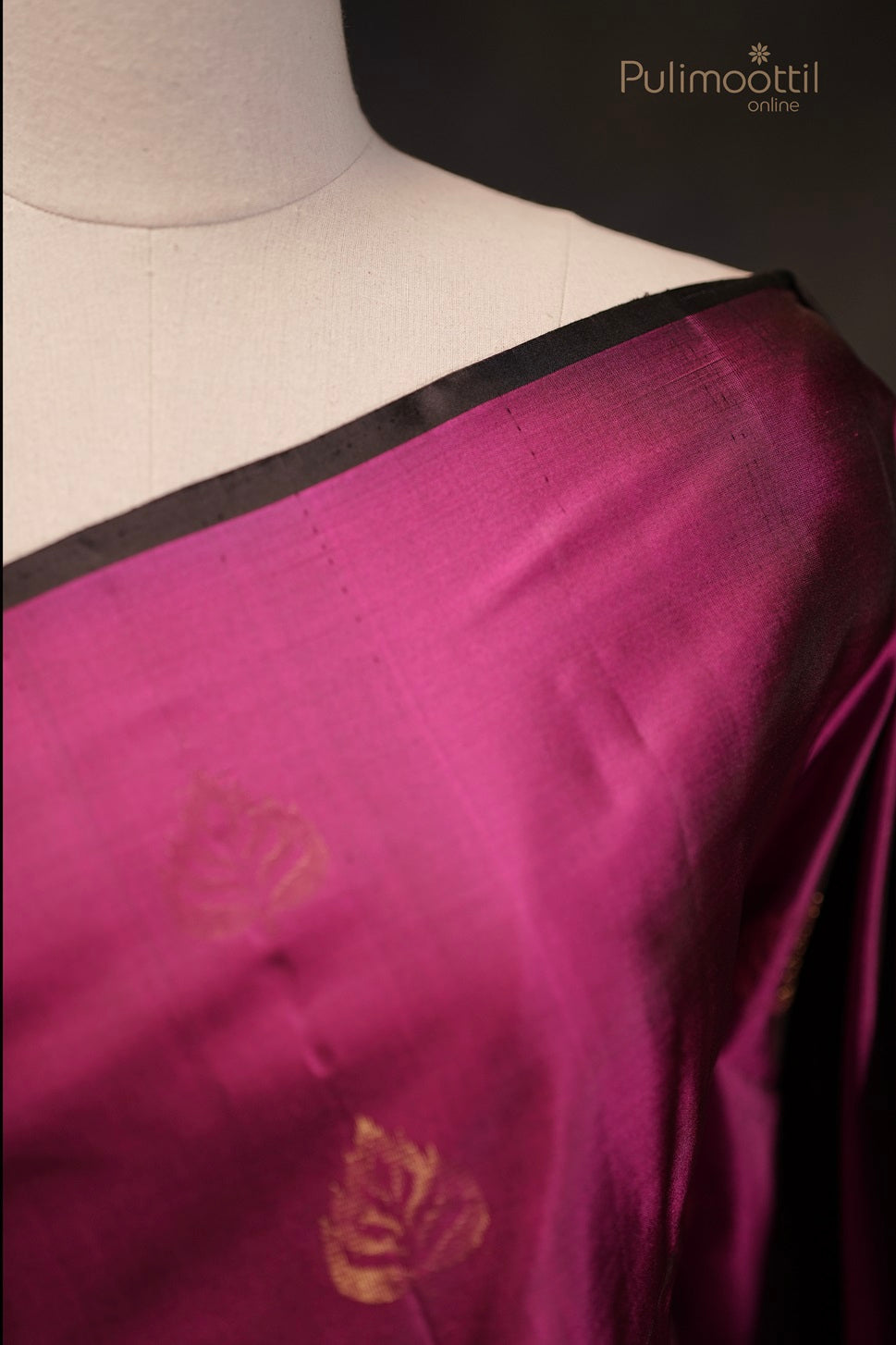 Close-up of golden leaf buttas and temple border on dark pink Kanchipuram soft silk saree.