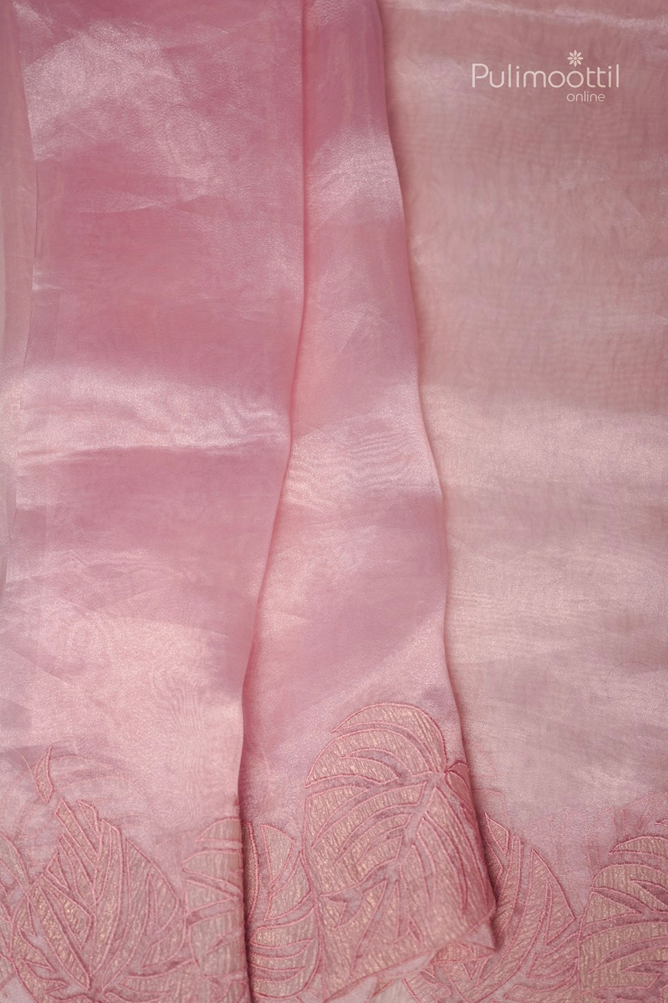 Close-up of light rose organza saree showing plain body and detailed applique work border, ideal for bridal and wedding sarees from Thrissur Pulimoottil Silks.