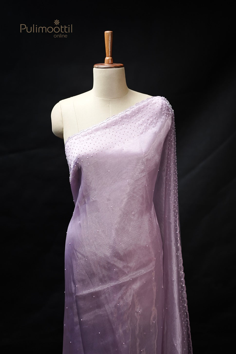 Lavender organza fancy saree displayed on a mannequin, featuring a bead-studded scallop border and a soft, elegant texture