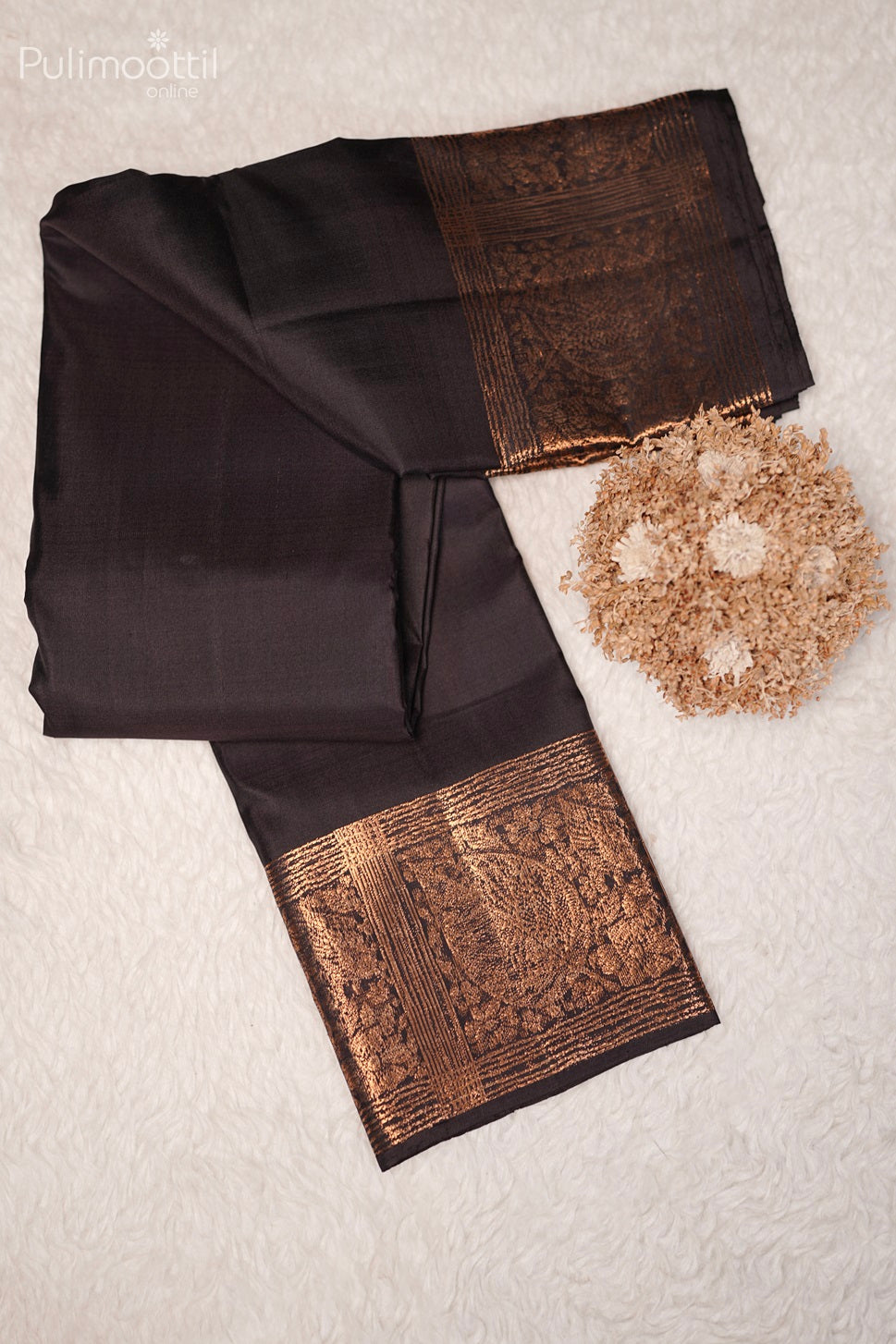 Close-up of the designer pallu of the black Kanchipuram soft silk saree with intricate gold zari work.