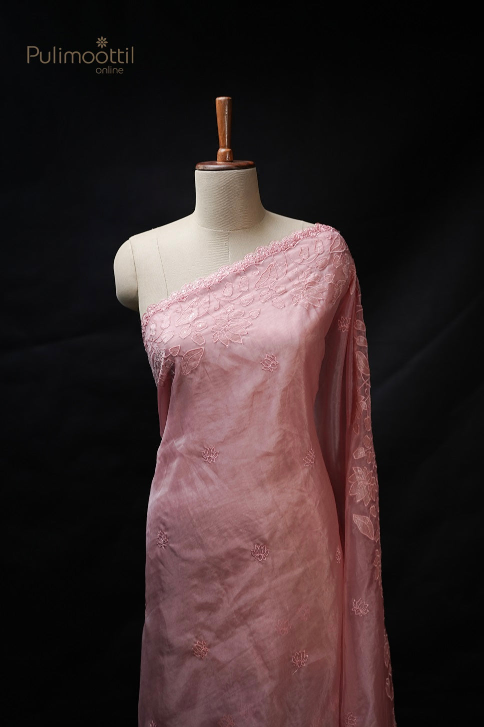 Peach colour organza fancy saree draped on mannequin, featuring small lotus embroidery buttas and lotus cut work scallop border, from Thrissur Pulimoottil Silks, perfect for wedding and bridal sarees.