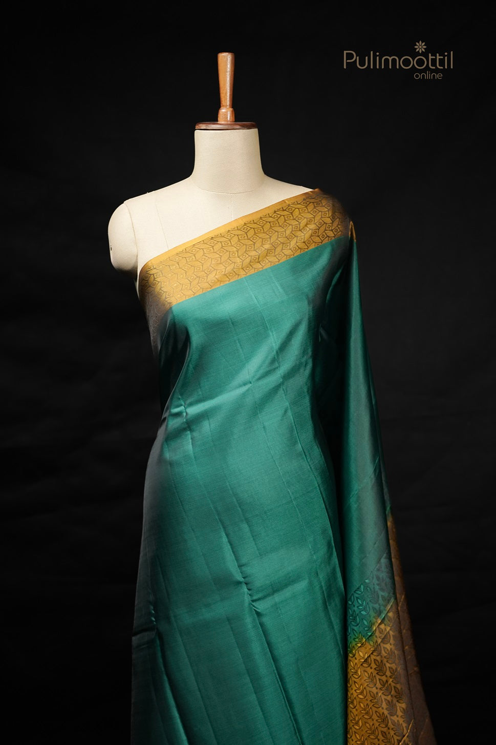 Peacock green Kanchipuram saree with contrast golden self print border draped on mannequin