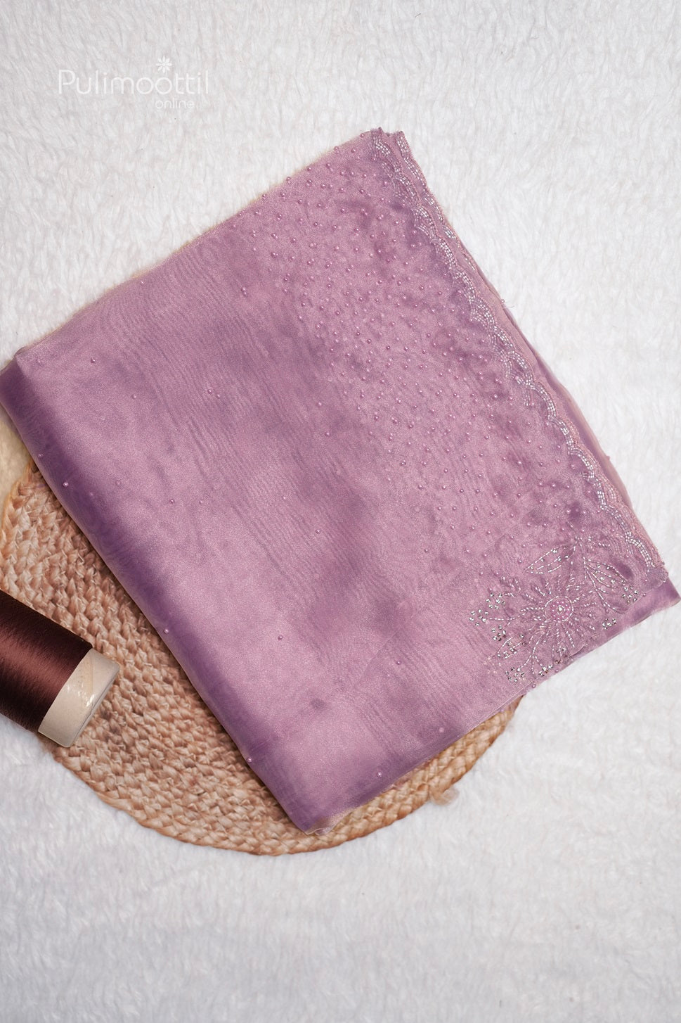 Close-up of the lavender organza blouse fabric with delicate pearl embellishments and a scallop border