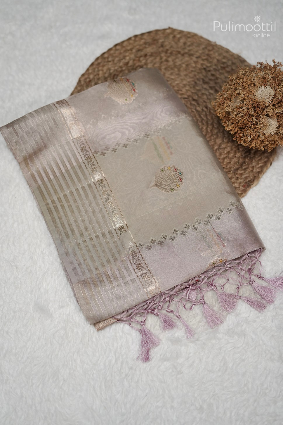 Folded ivory Banarasi silk saree with golden and multithread designs, red border, and tassel pallu, perfect for bridal saree or party wear.