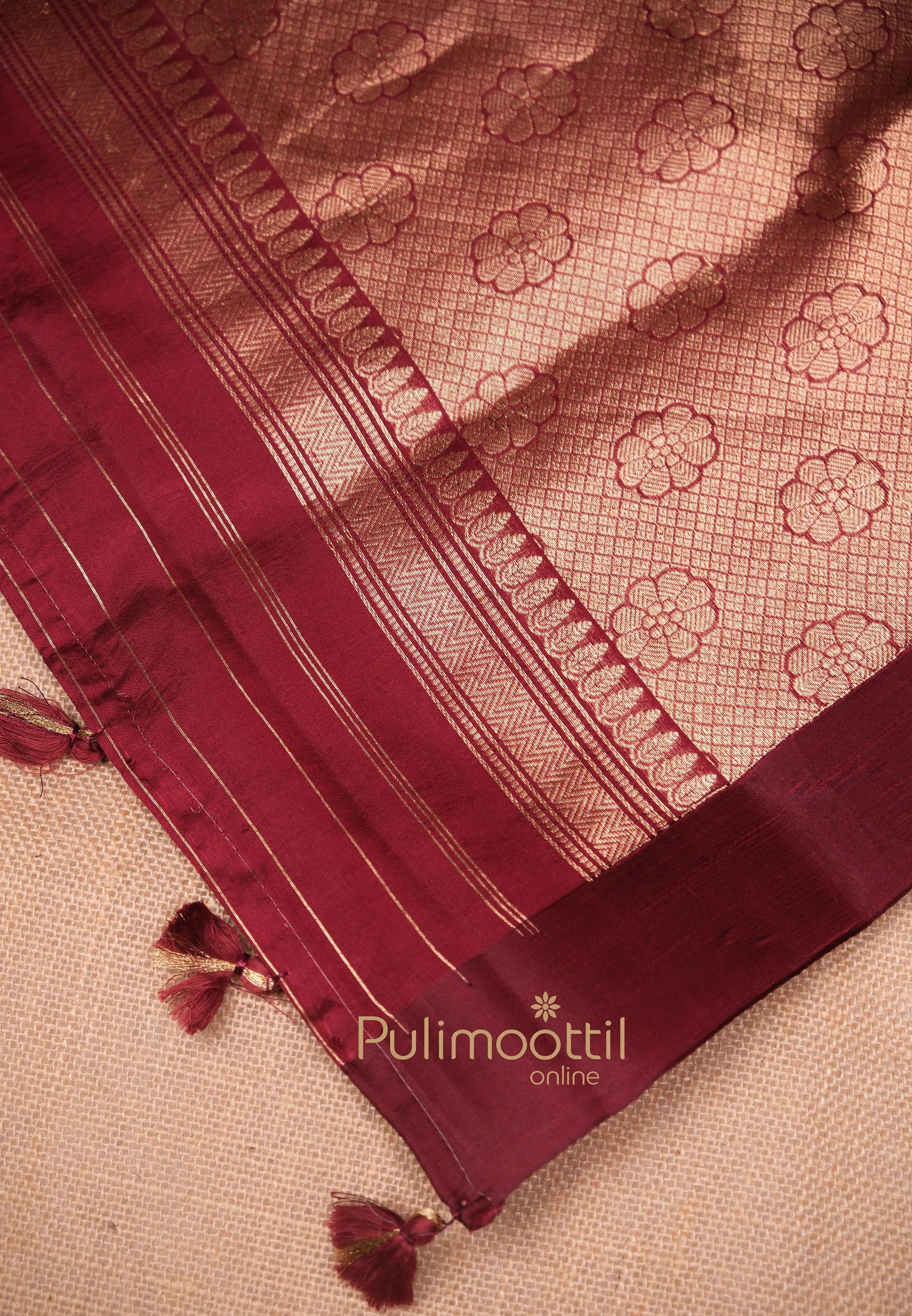 Richly woven pallu of maroon mango silk saree featuring floral gold zari pattern and tassel details – perfect for bridal wear and festive wedding sarees.