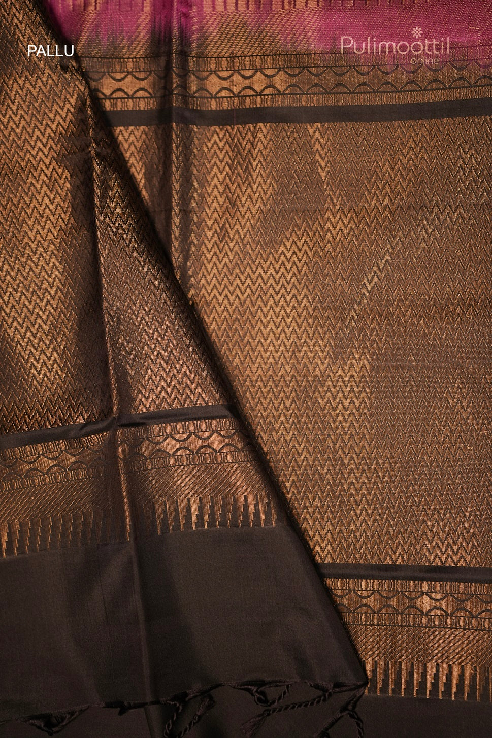 Detailed close-up of the black zig zag design pallu with golden zari work on the dark pink Kanchipuram saree.