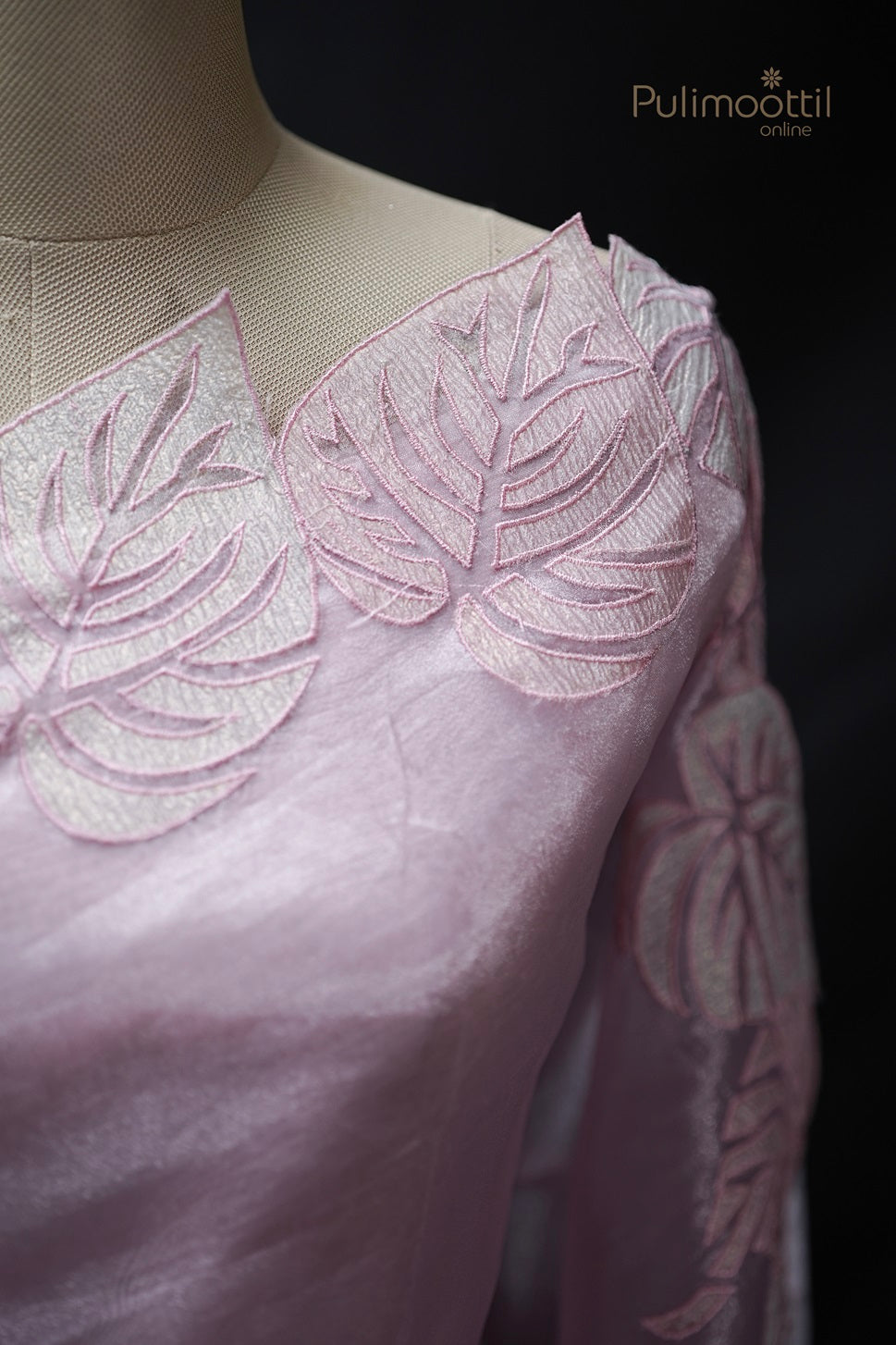 Detailed close-up of light rose organza saree blouse with full applique work, showcasing intricate embroidery for wedding and bridal sarees by Pulimoottil Silks Thrissur.