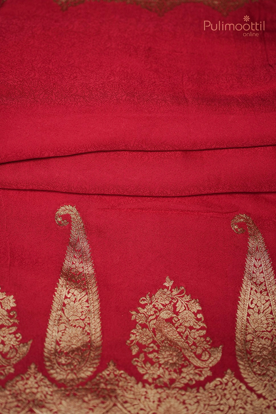 Close-up of golden scallop floral border on chili red Banarasi silk saree