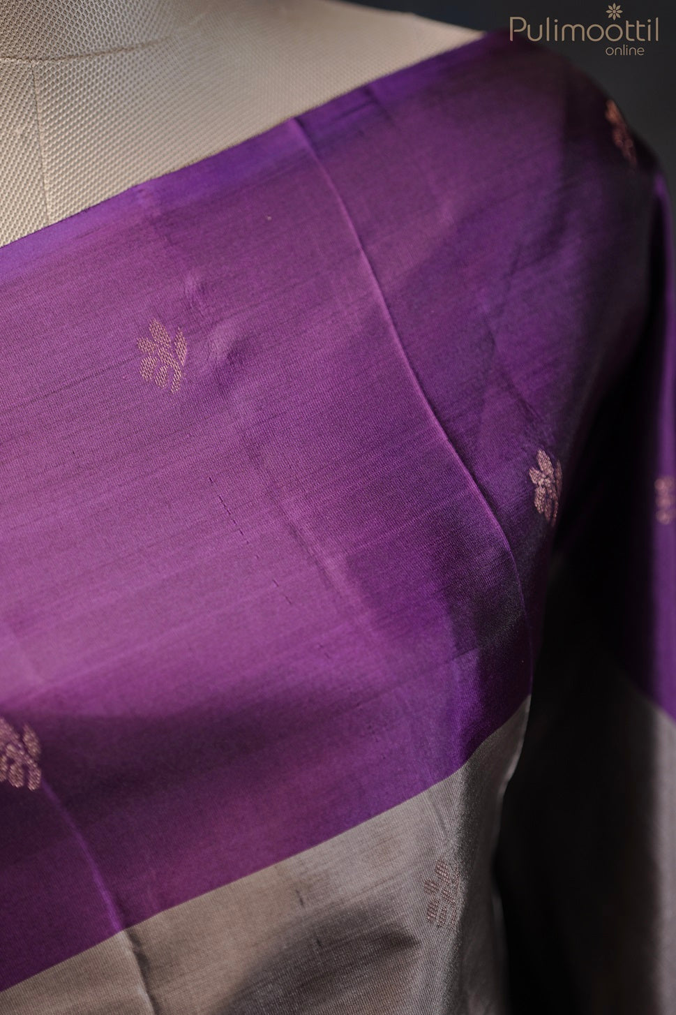 Close-up of the purple contrast border with golden buttas on the Kanchipuram soft silk saree, draped on a mannequin.